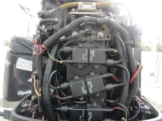 Close-up of a 1999 Boston Whaler 23 Outrage engine with visible wiring and components.