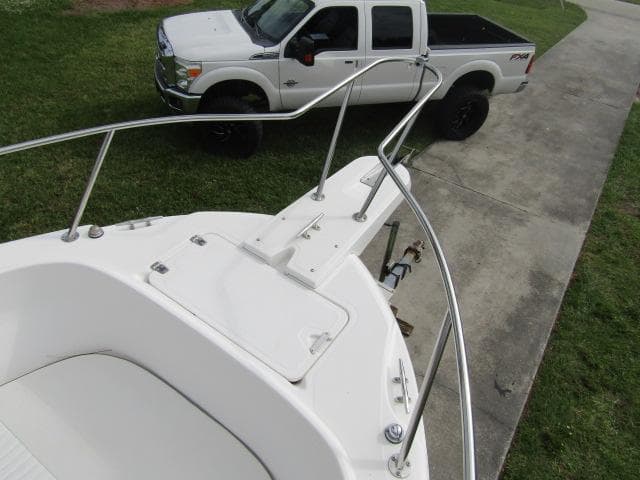 1999 Boston Whaler 23 Outrage boat on trailer, parked near white pickup truck.