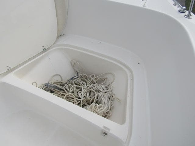 Open storage compartment with ropes on a 1999 Boston Whaler 23 Outrage boat.