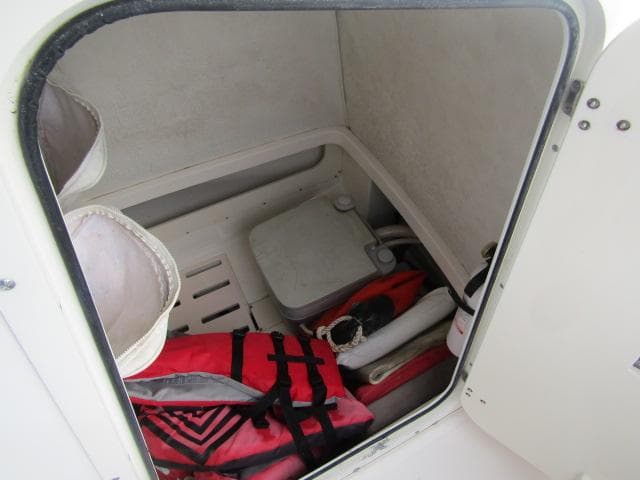 Interior storage of 1999 Boston Whaler 23 Outrage with life jackets and equipment.