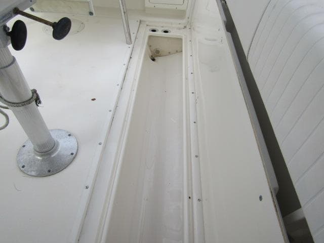 1999 Boston Whaler 23 Outrage interior showing storage compartment and seating area.