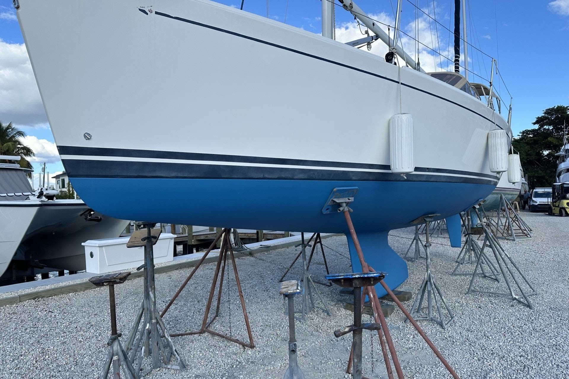 2004 J Boats J/32 sailboat on stands, white hull with blue bottom, marina setting.