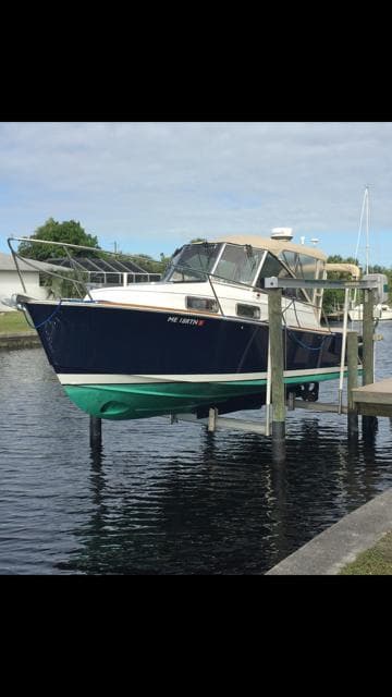2002 Legacy Yachts 28 Express docked, featuring a sleek design and classic navy hull.