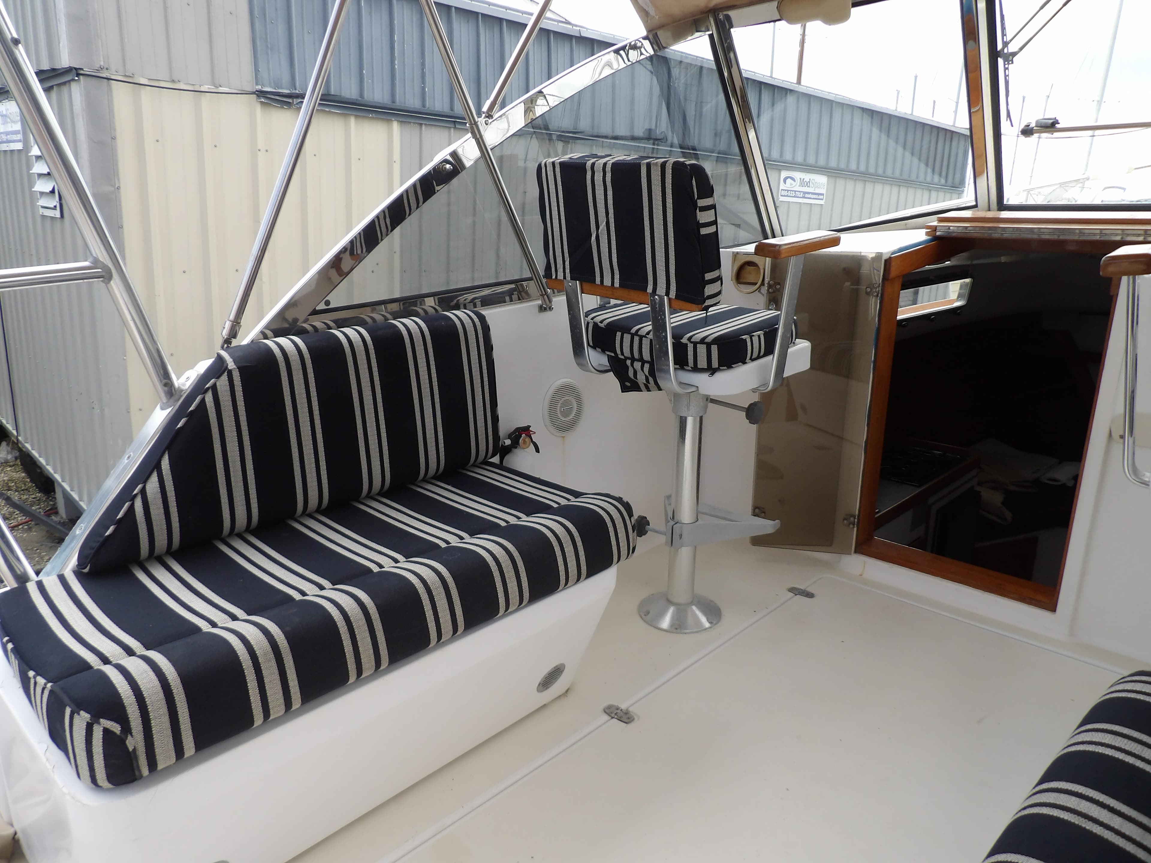 2002 Legacy Yachts 28 Express interior with striped seating and helm chair.