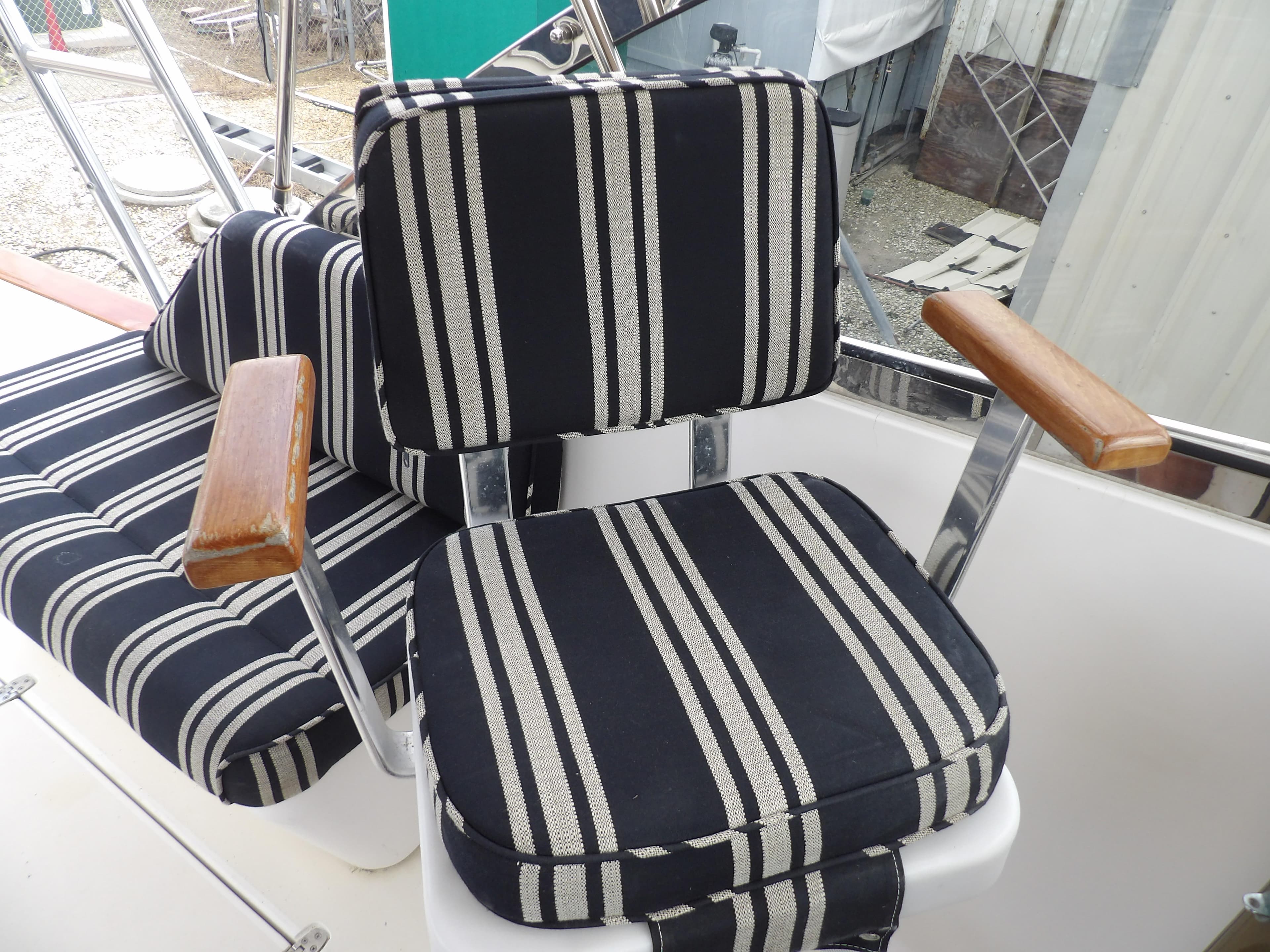 Striped seating on 2002 Legacy Yachts 28 Express with wooden armrests.