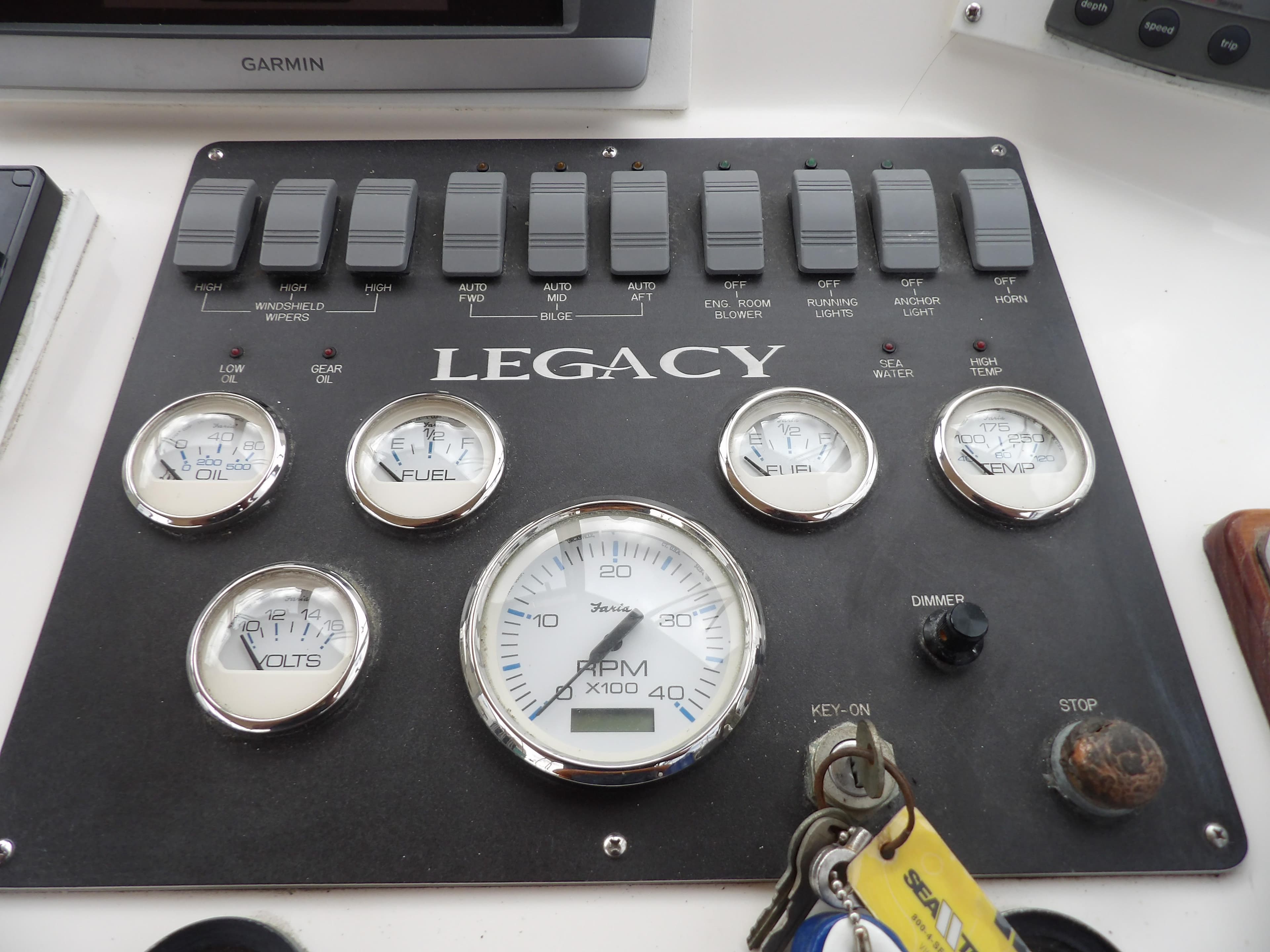 Control panel of a 2002 Legacy Yachts 28 Express with gauges and switches.
