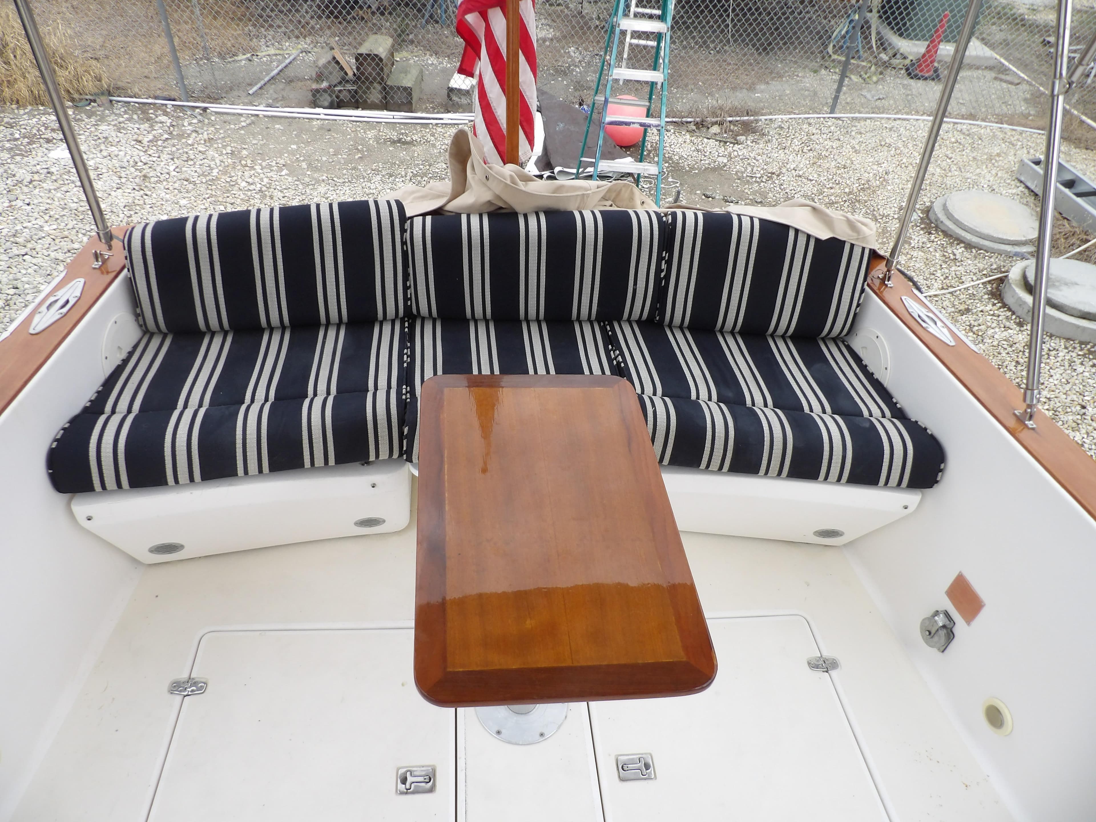 Legacy Yachts 28 Express 2002 boat interior with striped seating and wooden table.