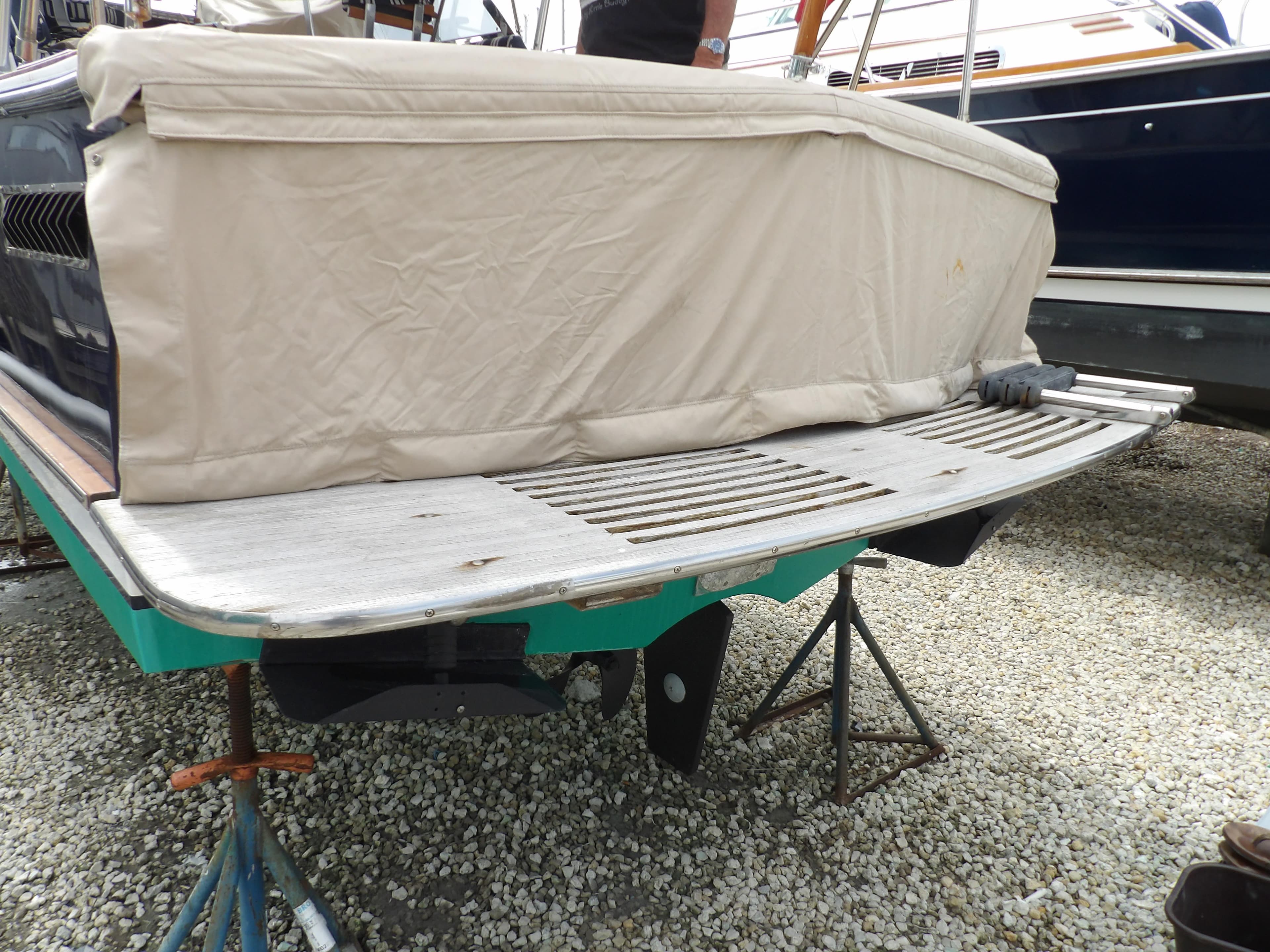 2002 Legacy Yachts 28 Express with covered stern, on stands, gravel ground.