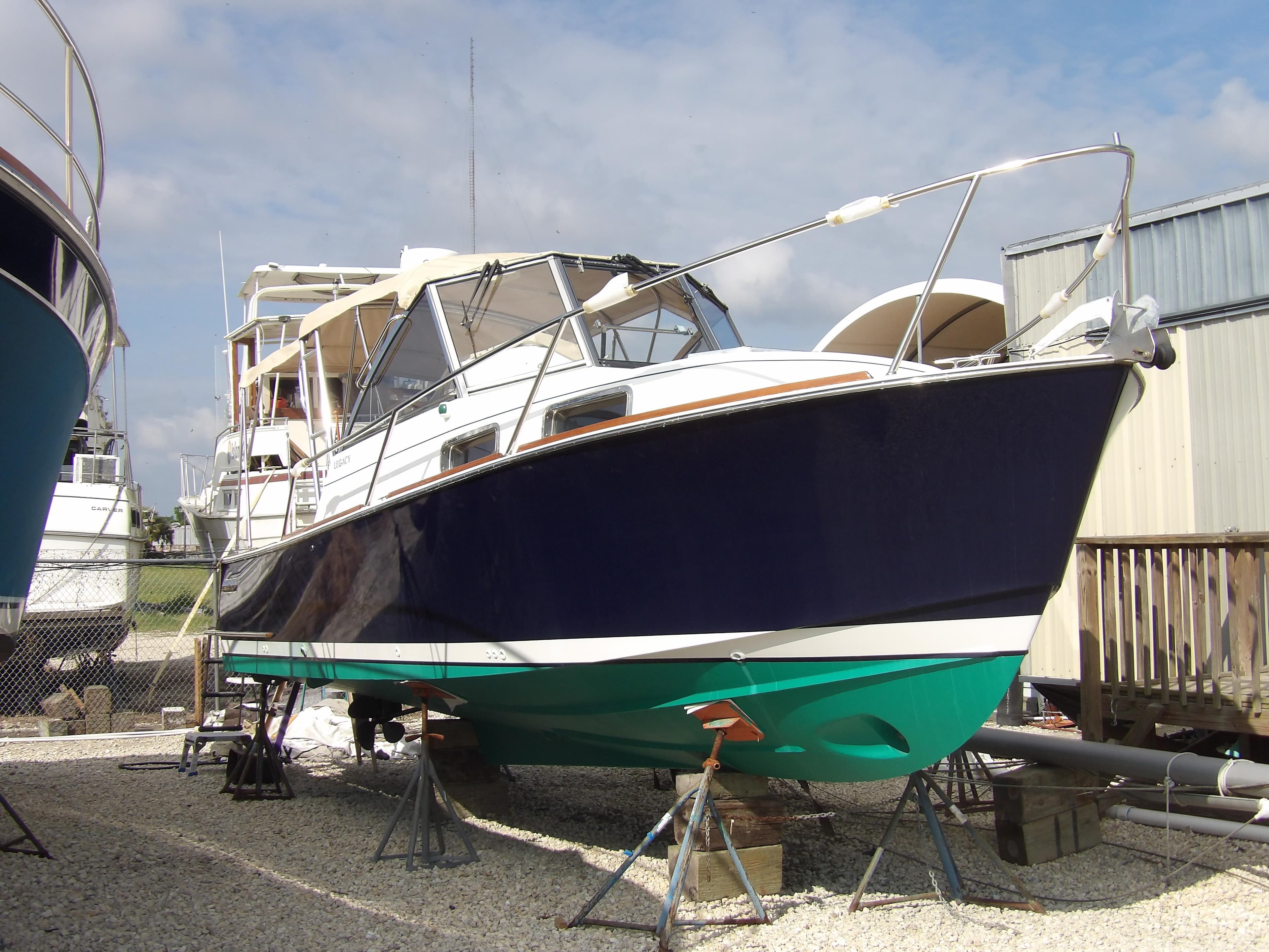 2002 Legacy Yachts 28 Express on stands, blue hull, green bottom, outdoor storage.