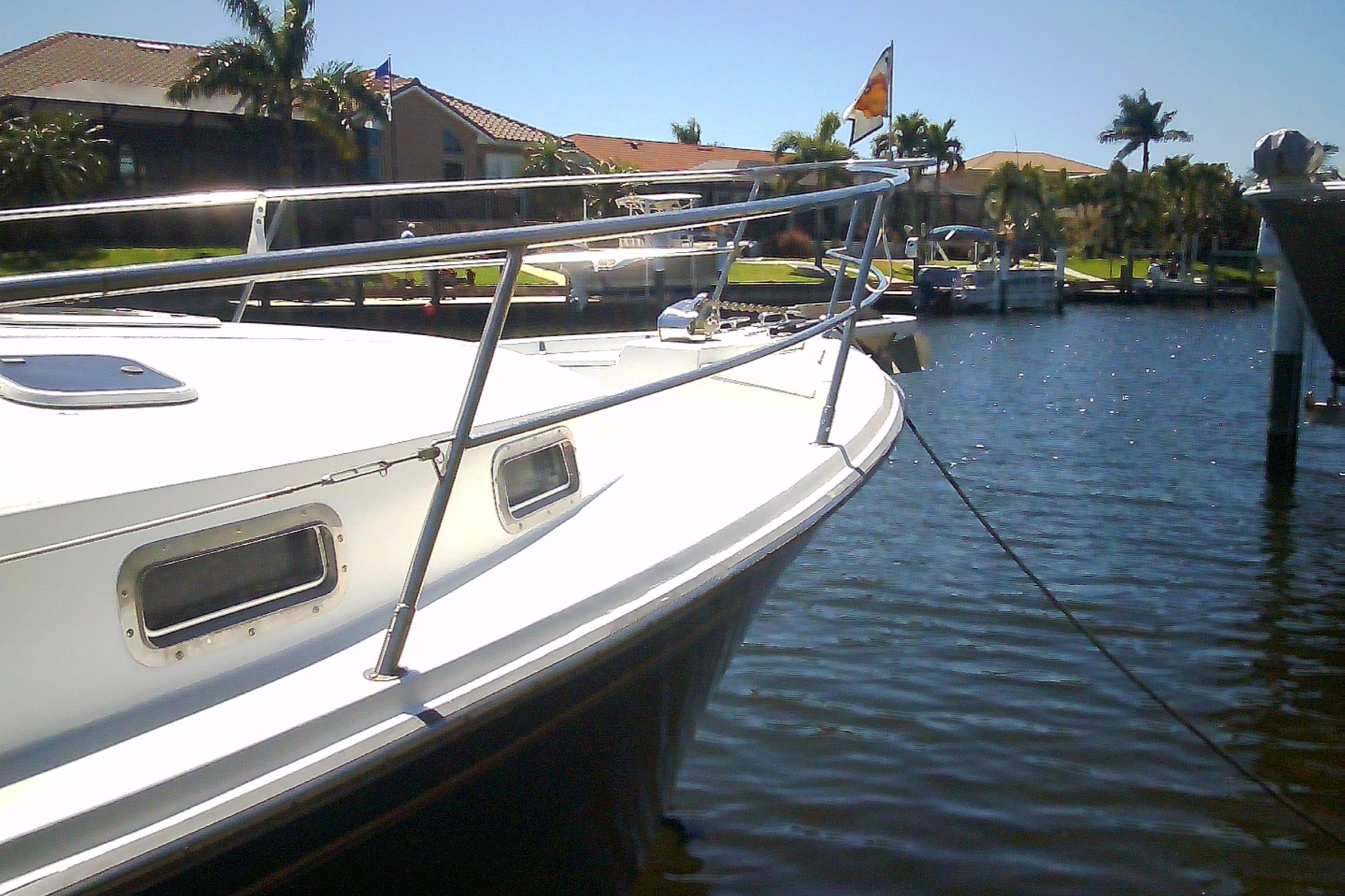 1999 Sabre 34 boat docked in a sunny marina with palm trees.