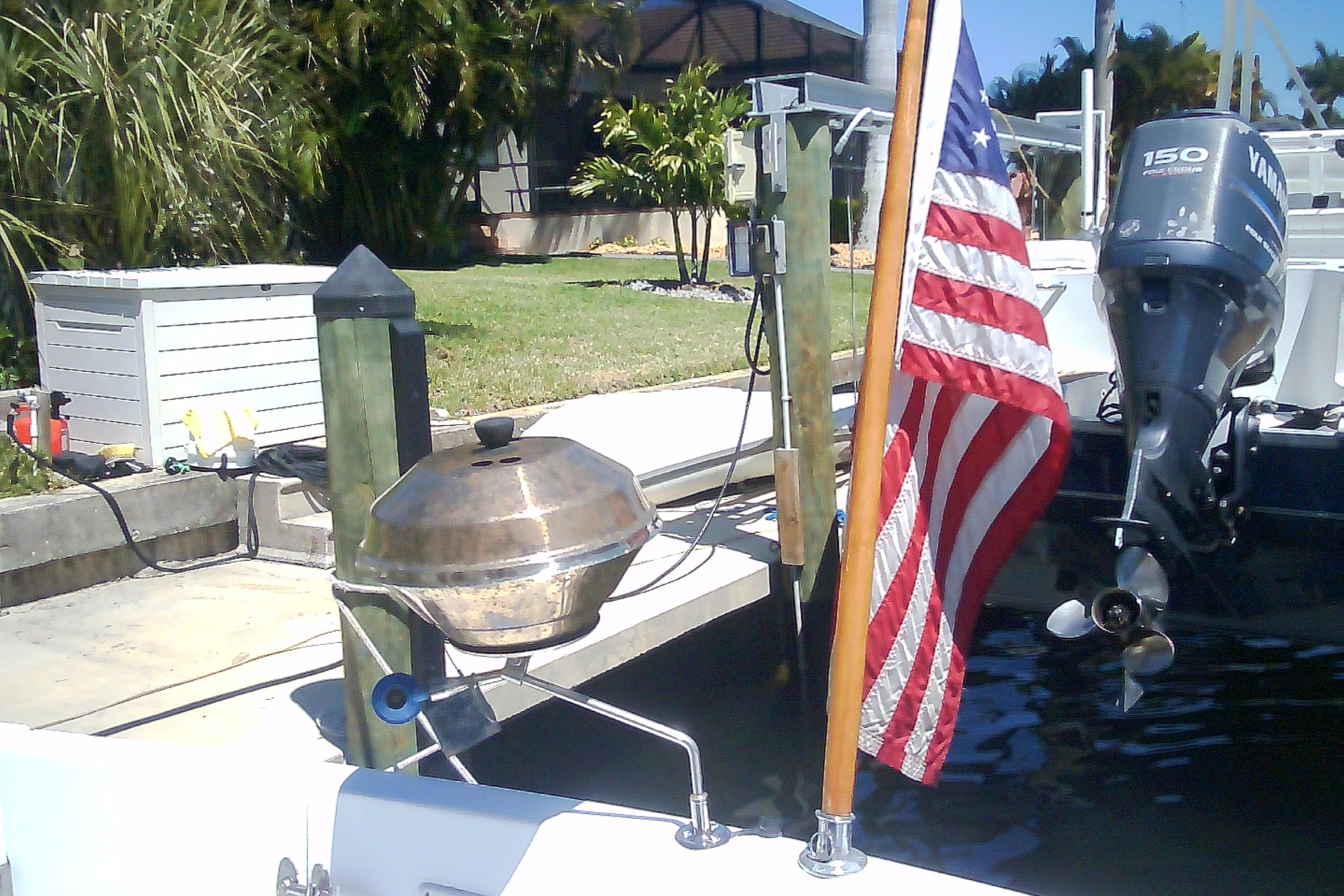 Boat docked with American flag and grill, featuring a Yamaha outboard motor. Sabre 34, 1999 model.