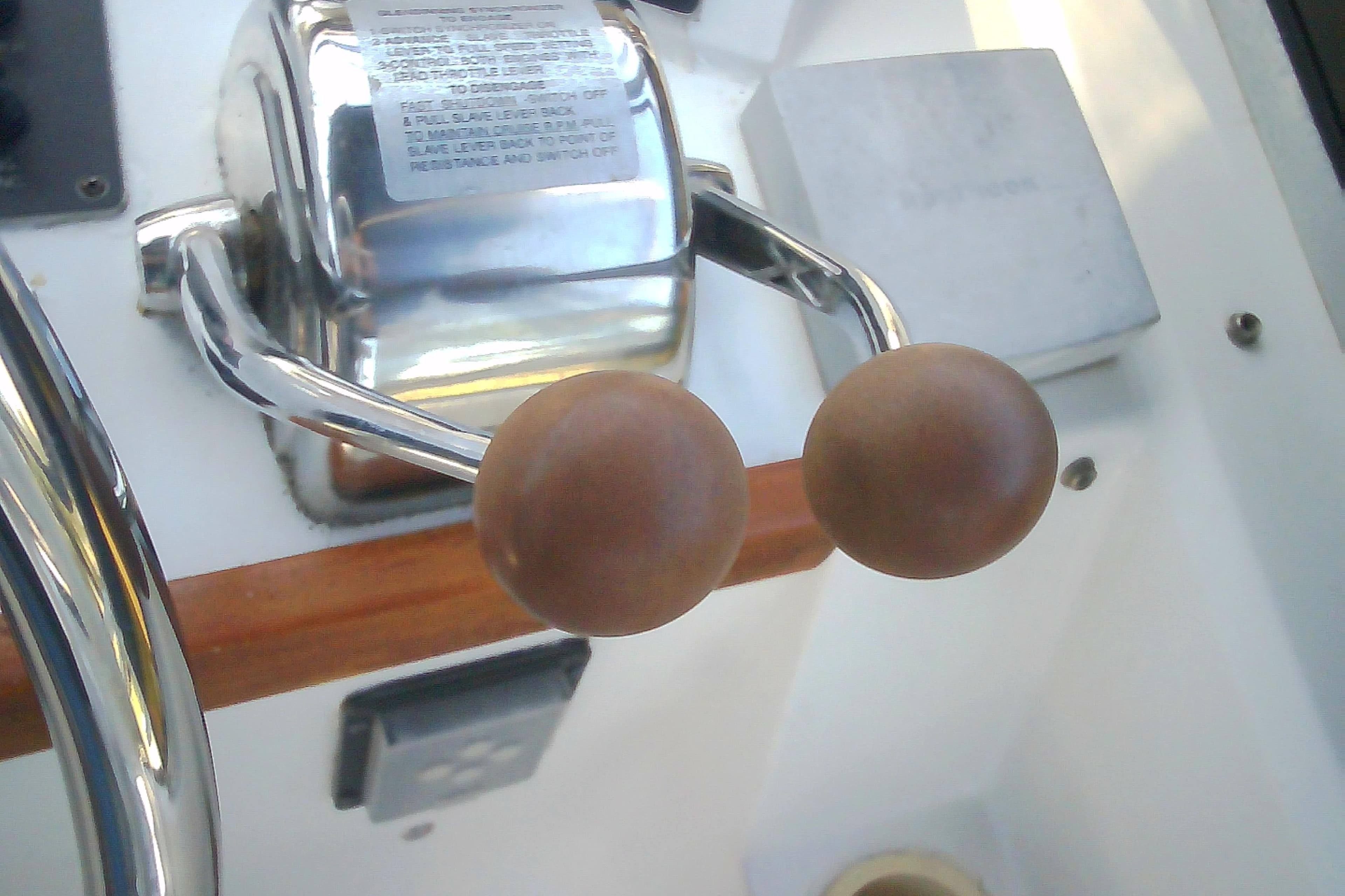 Throttle controls on a 1999 Sabre 34 boat, featuring wooden handles and chrome finish.