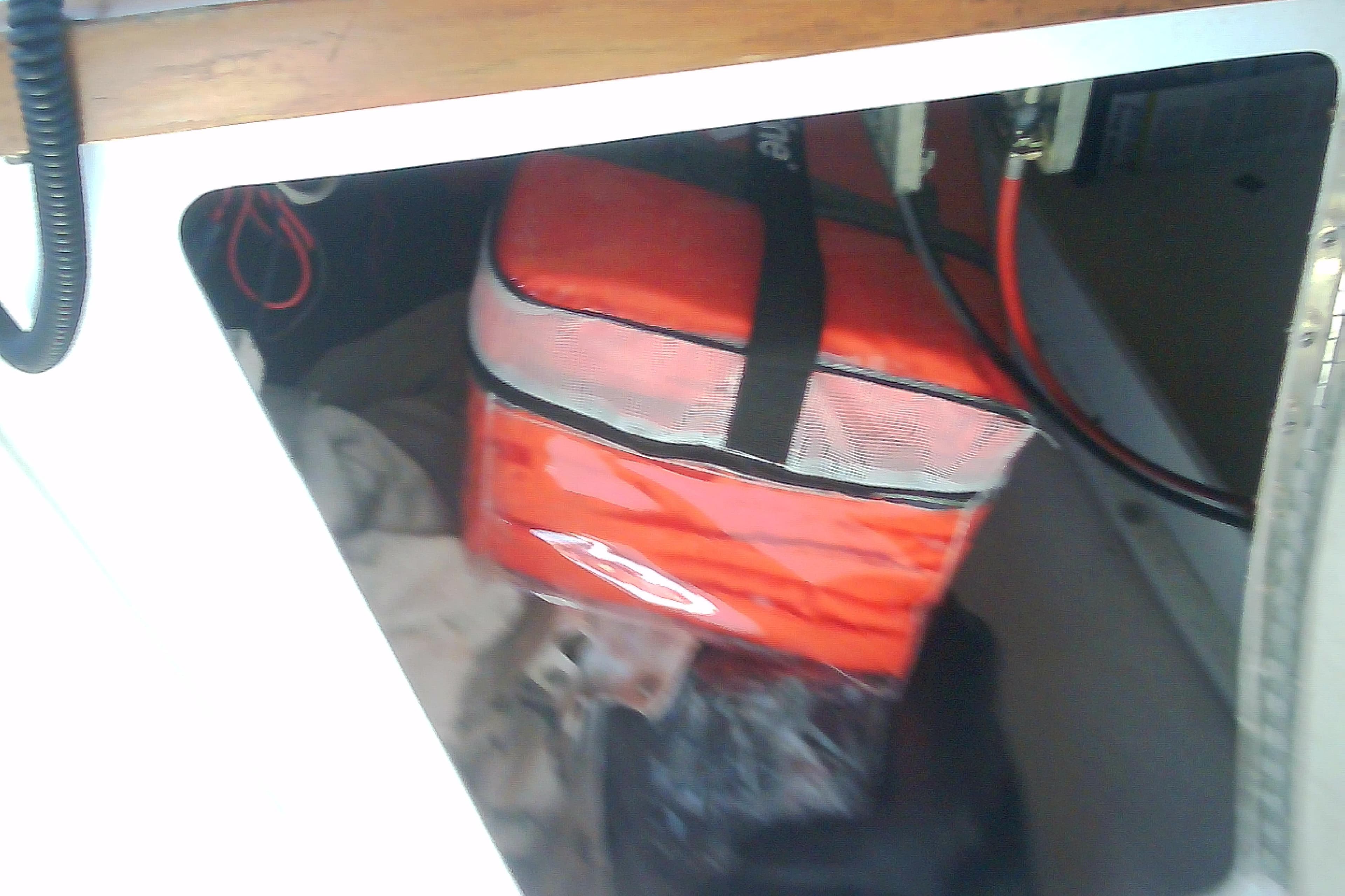 Storage compartment in a 1999 Sabre 34 boat with red bag and cables.