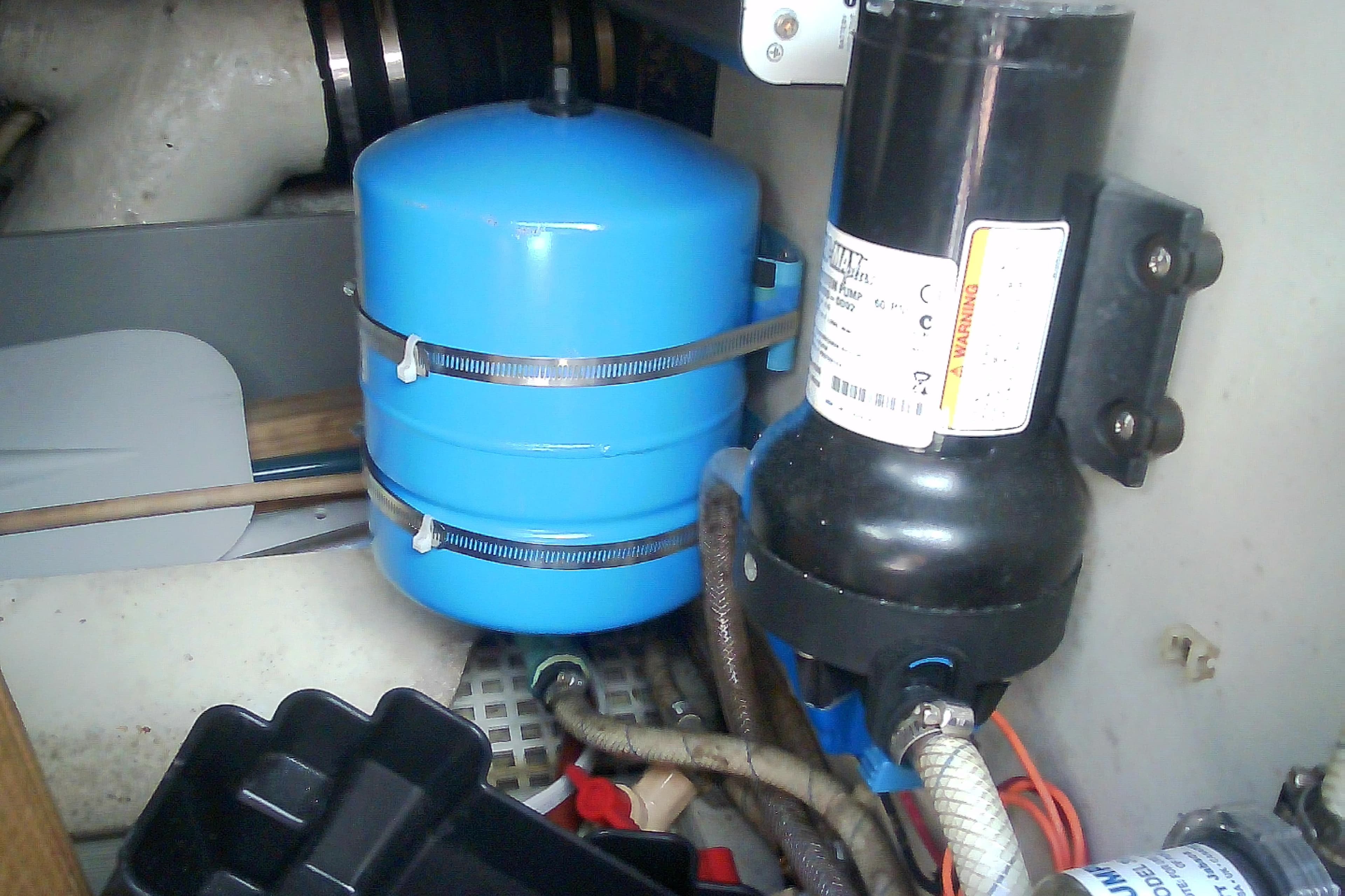 Engine compartment of a 1999 Sabre 34 with blue pressure tank and pump system.