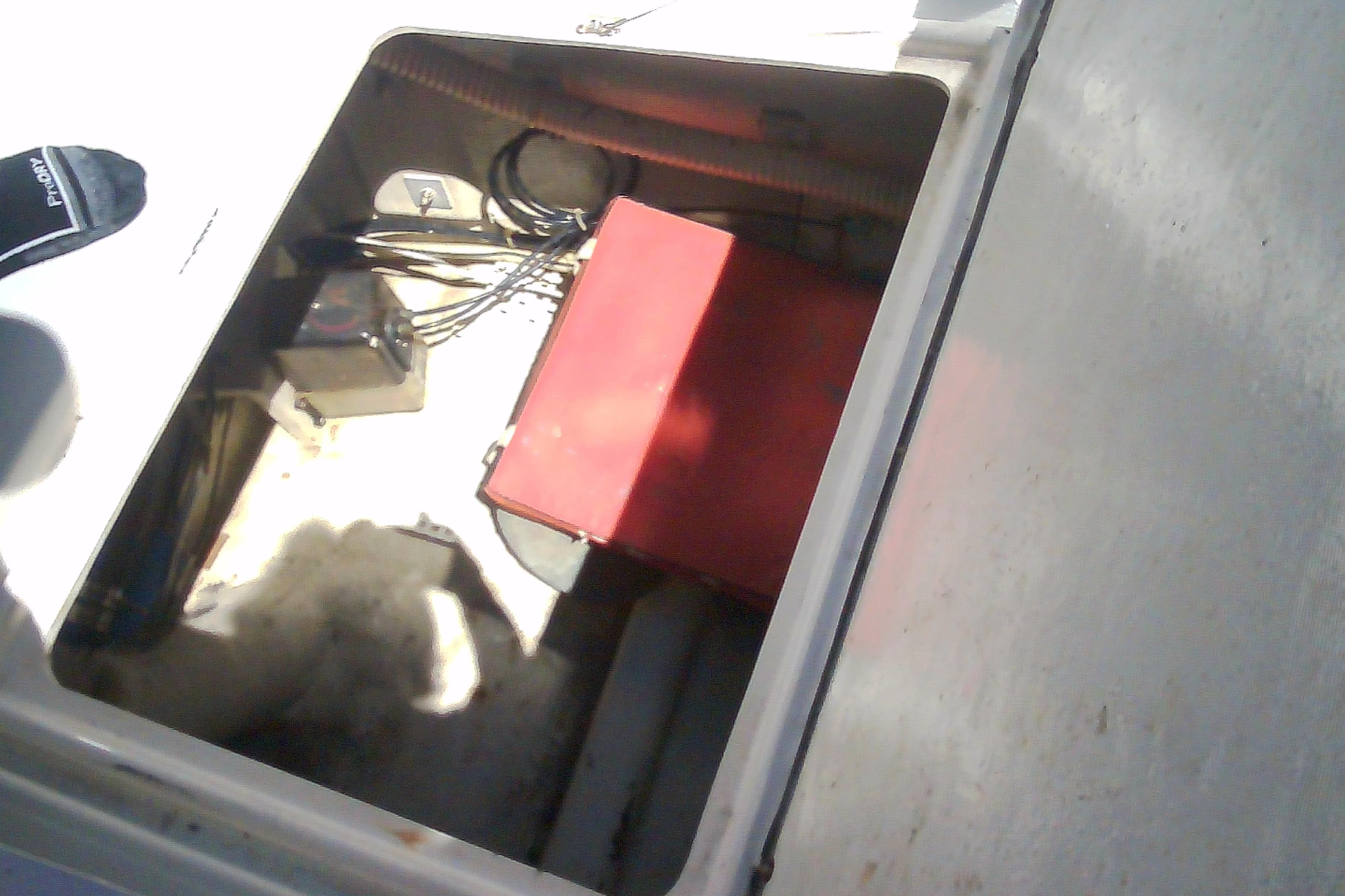 Open compartment of a 1999 Sabre 34 boat showing wiring and a red box.