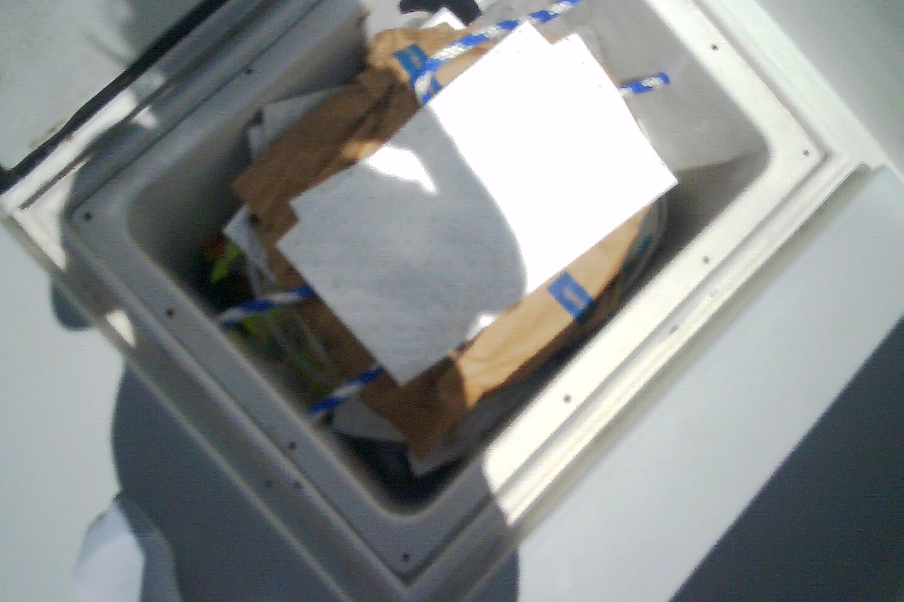 Open storage compartment on Sabre 34 boat, filled with various items, 1999 model.