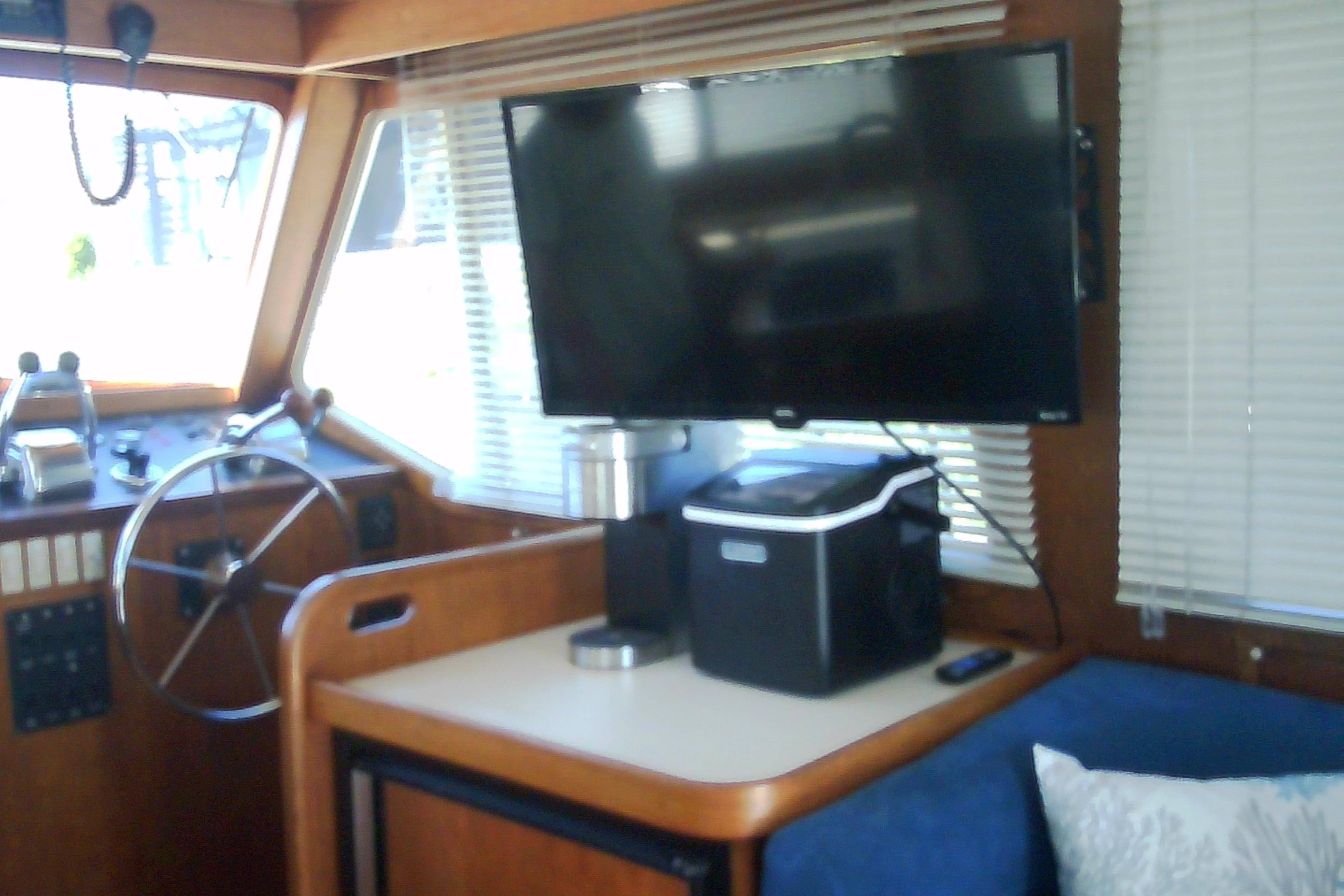 Interior of a 1999 Sabre 34 boat with steering wheel and mounted TV.