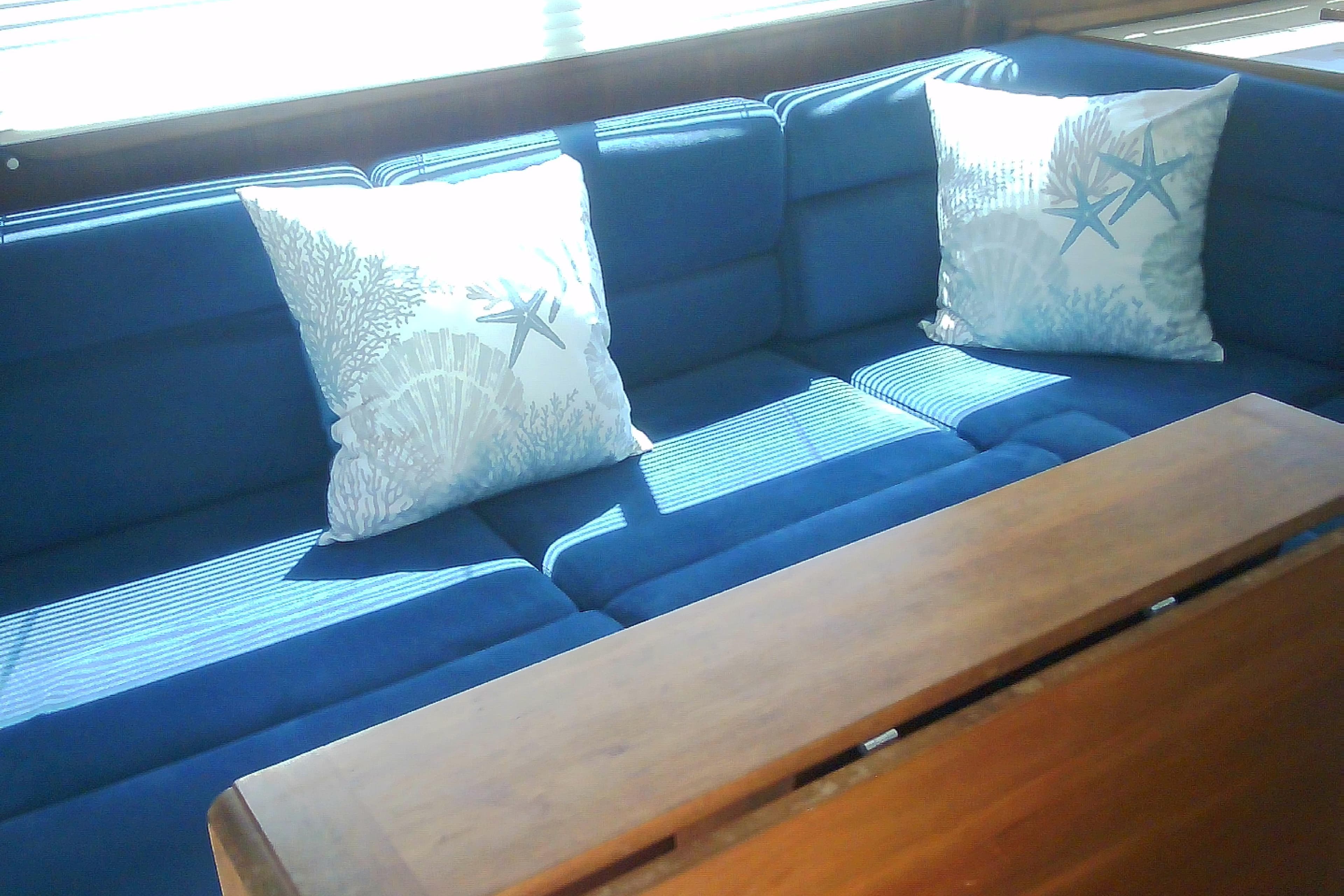 Blue cushioned seating with starfish pillows on a 1999 Sabre 34 yacht.