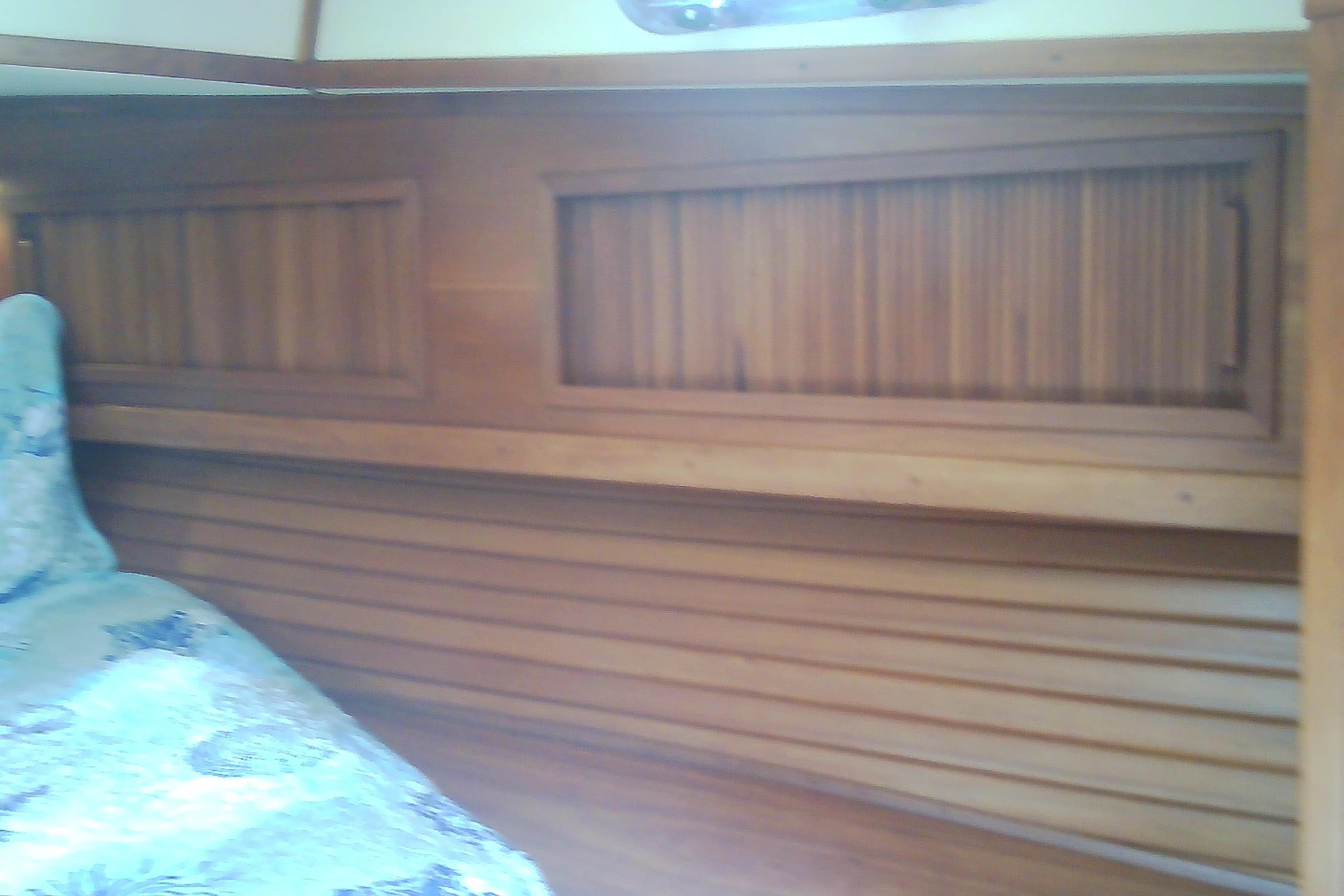 Interior of a 1999 Sabre 34 yacht with wooden paneling and a patterned bedspread.