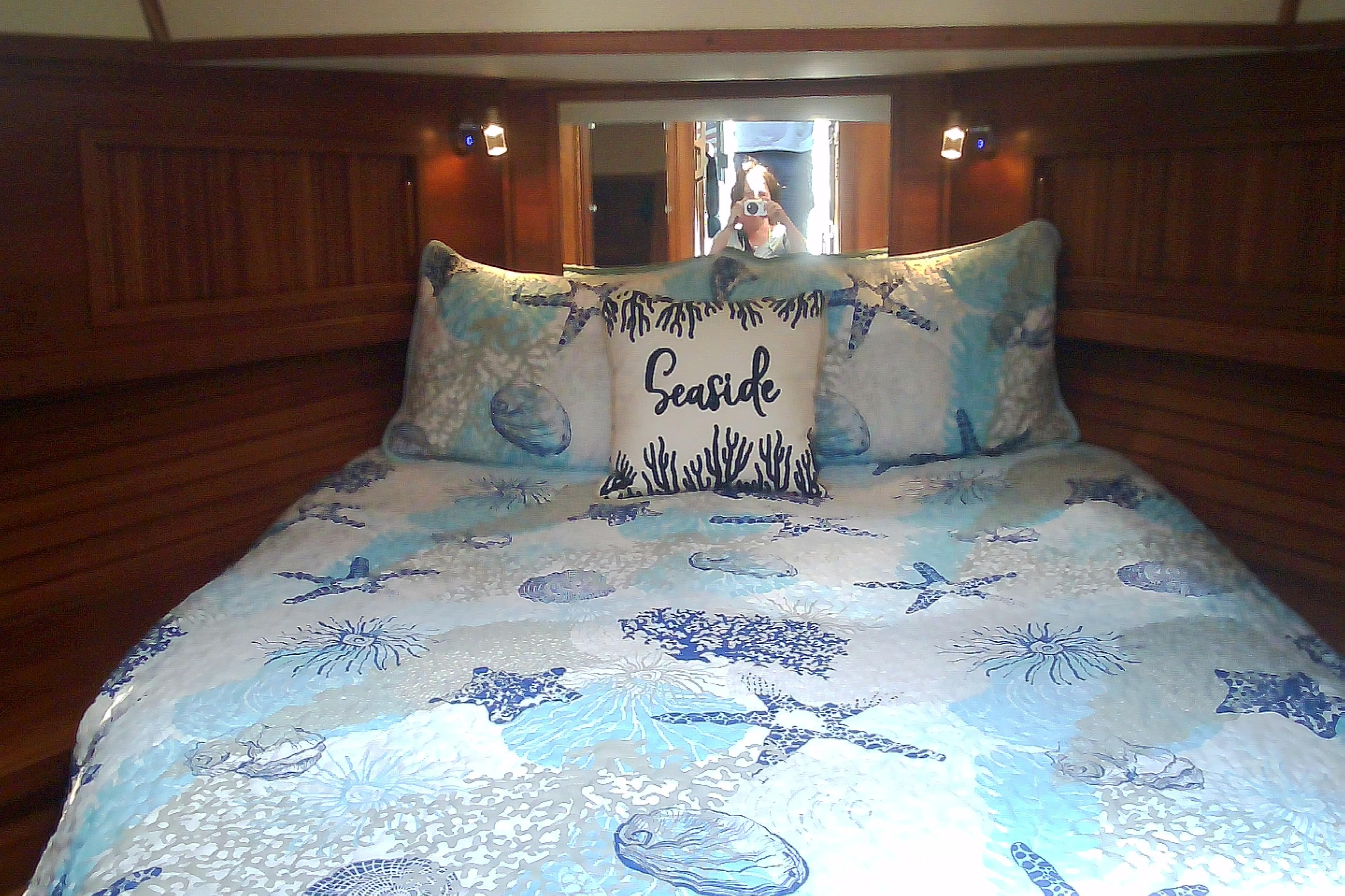 Cozy cabin bedroom in 1999 Sabre 34 yacht with seaside-themed bedding.