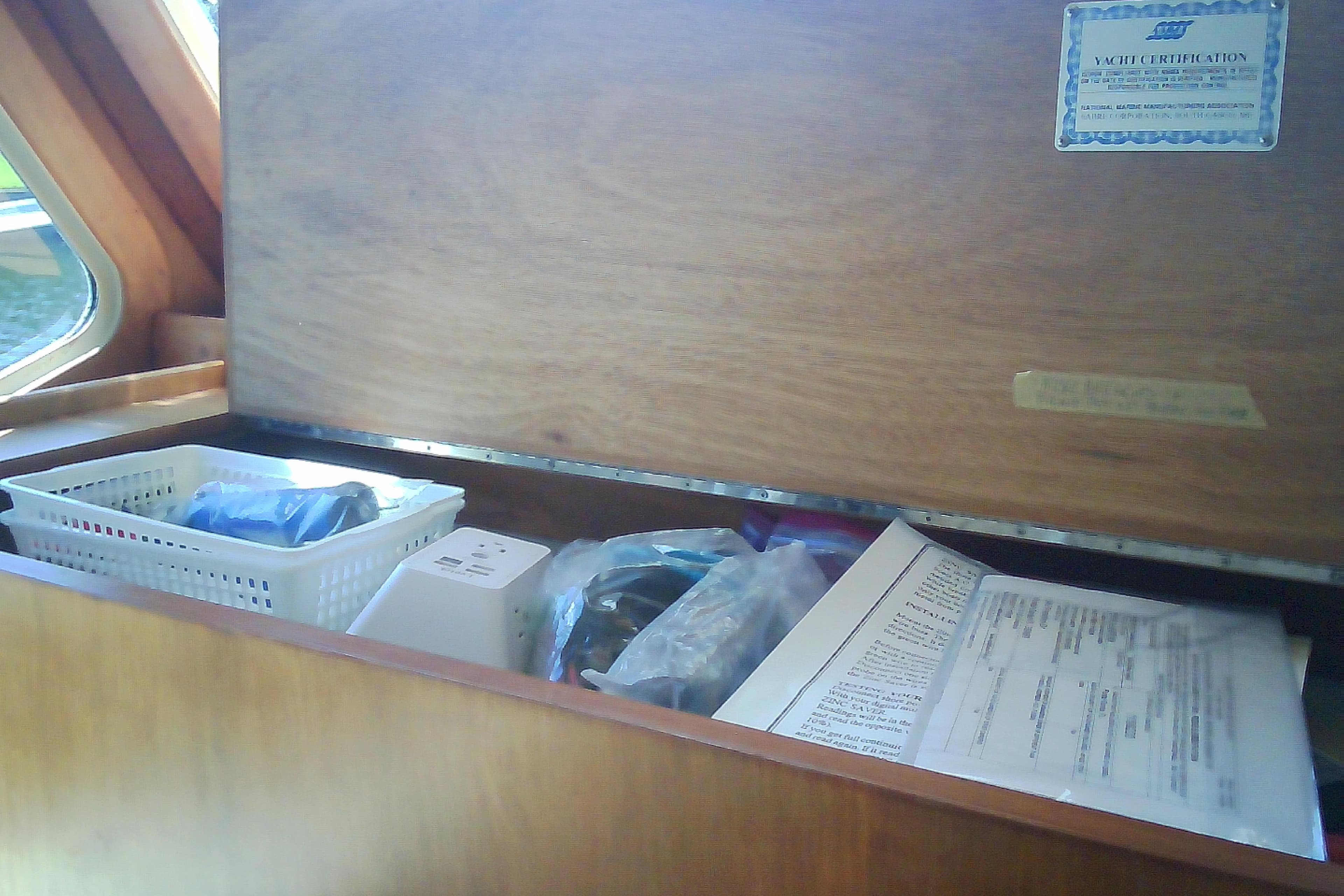 Interior storage compartment of a 1999 Sabre 34 yacht with documents and supplies.