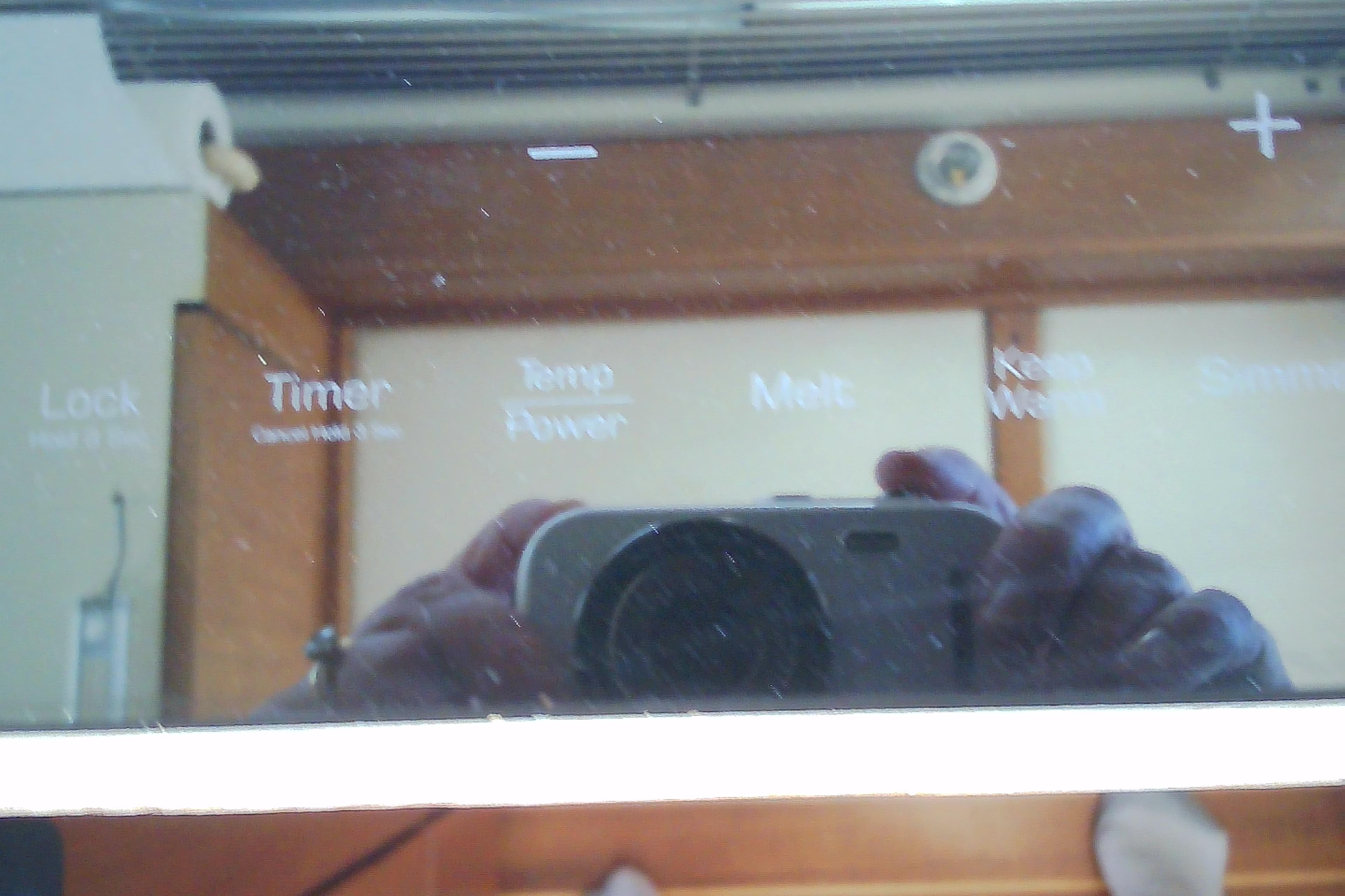 Reflection on a Sabre 34 boat's control panel, showing various settings and buttons.