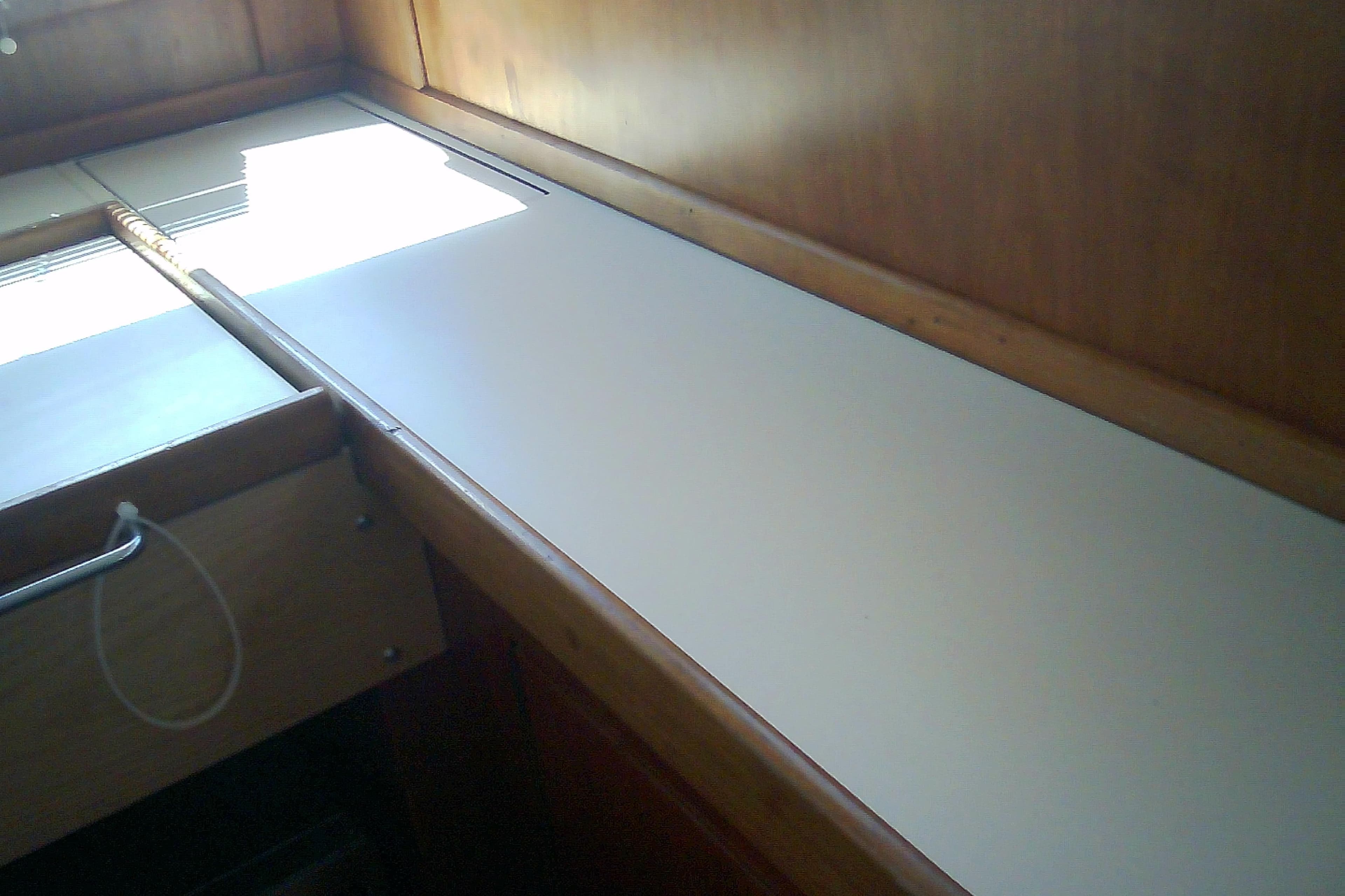 Interior view of a 1999 Sabre 34 sailboat, featuring a wooden cabin and countertop.