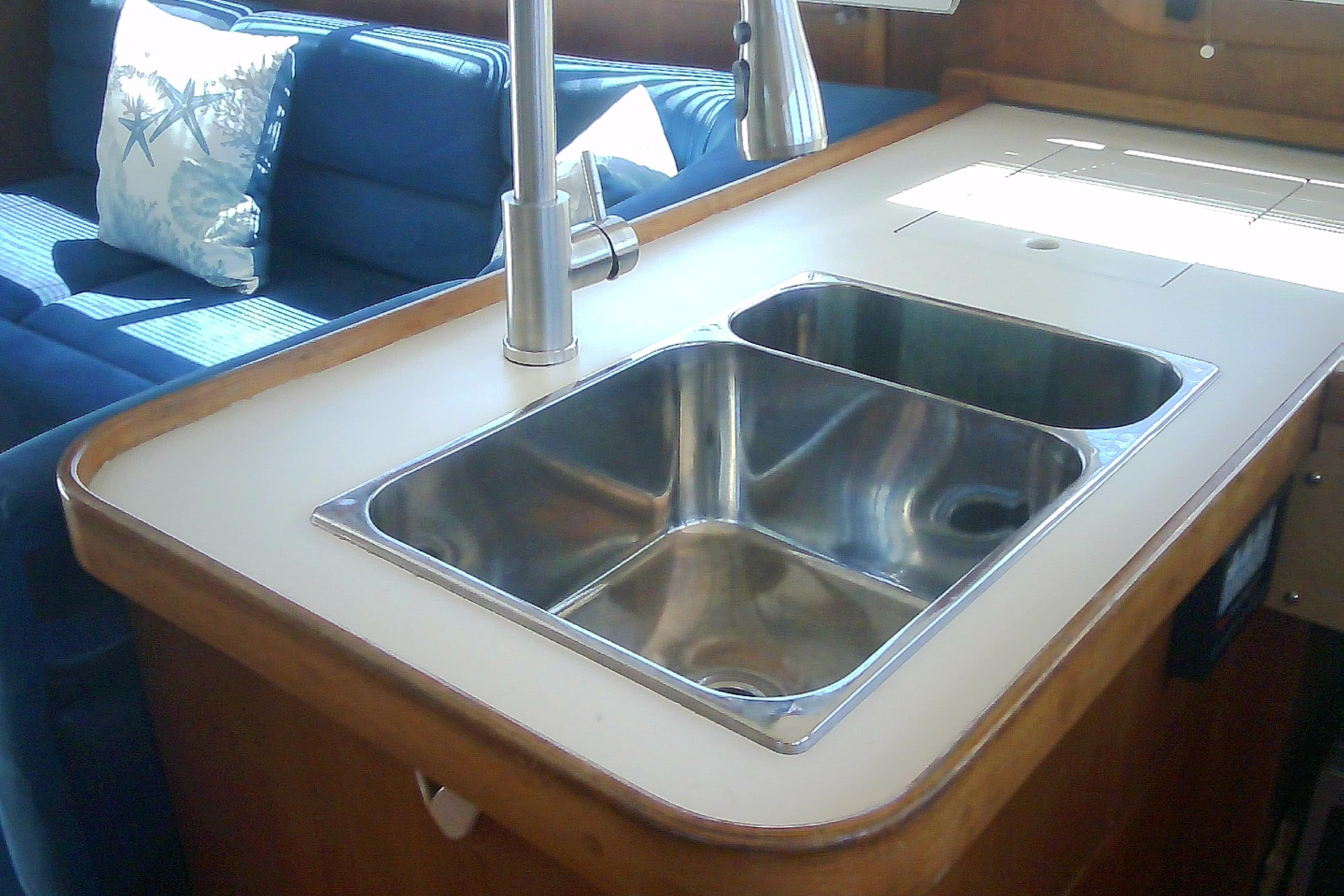 Stainless steel sink in 1999 Sabre 34 yacht kitchen with blue seating.