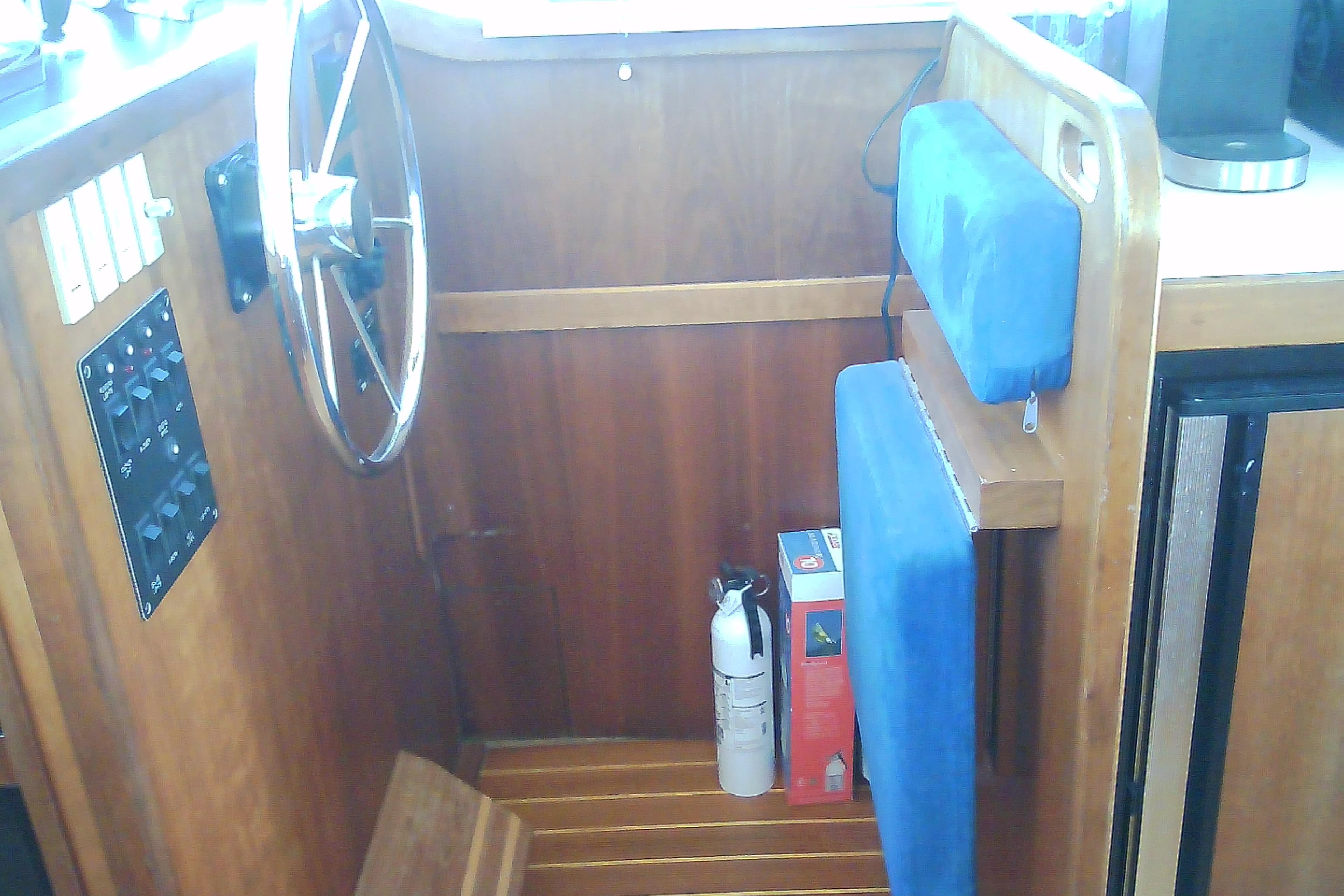 1999 Sabre 34 boat interior with steering wheel, control panel, and blue cushioned seating.