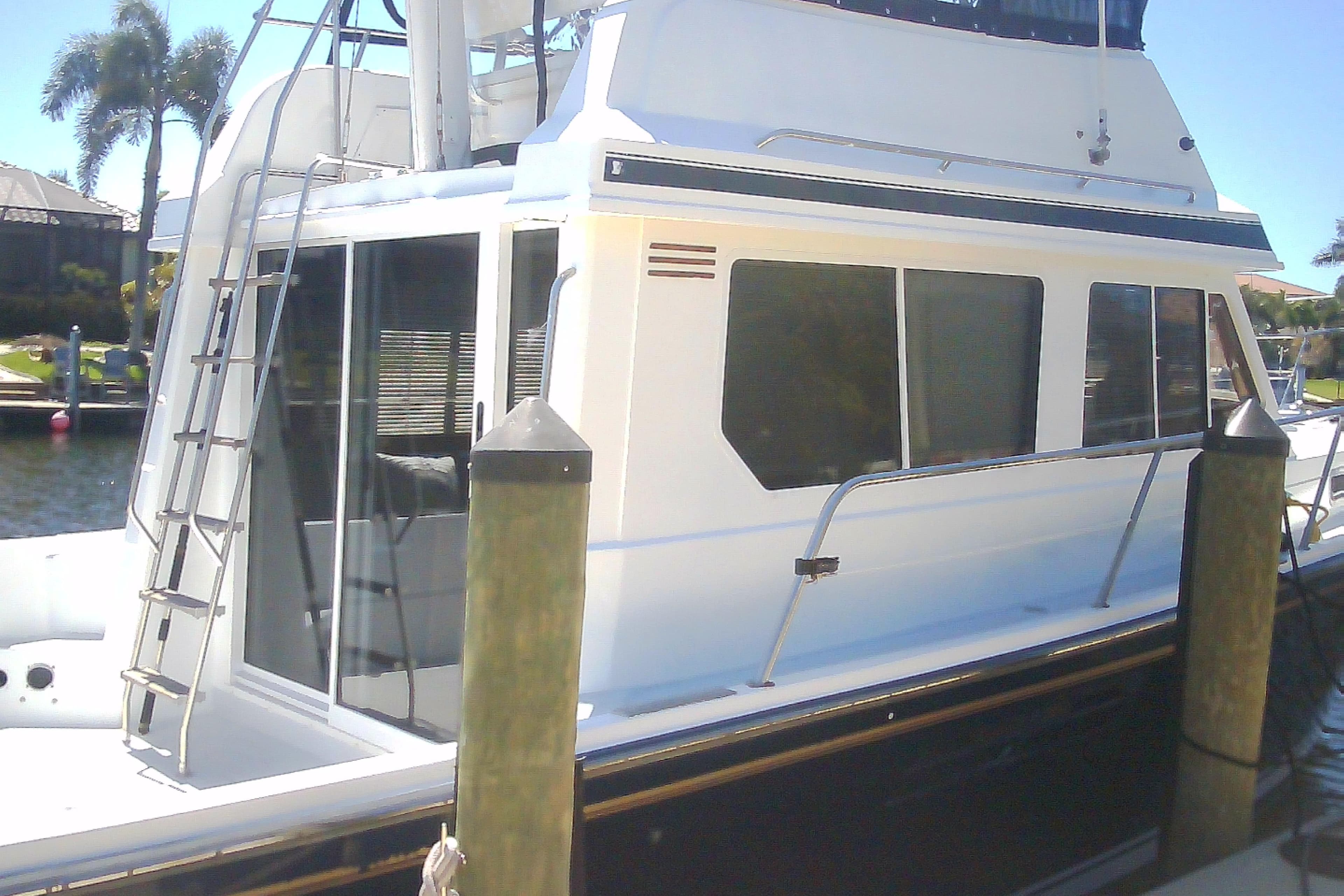 1999 Sabre 34 boat docked, featuring a sleek white exterior and ladder access.