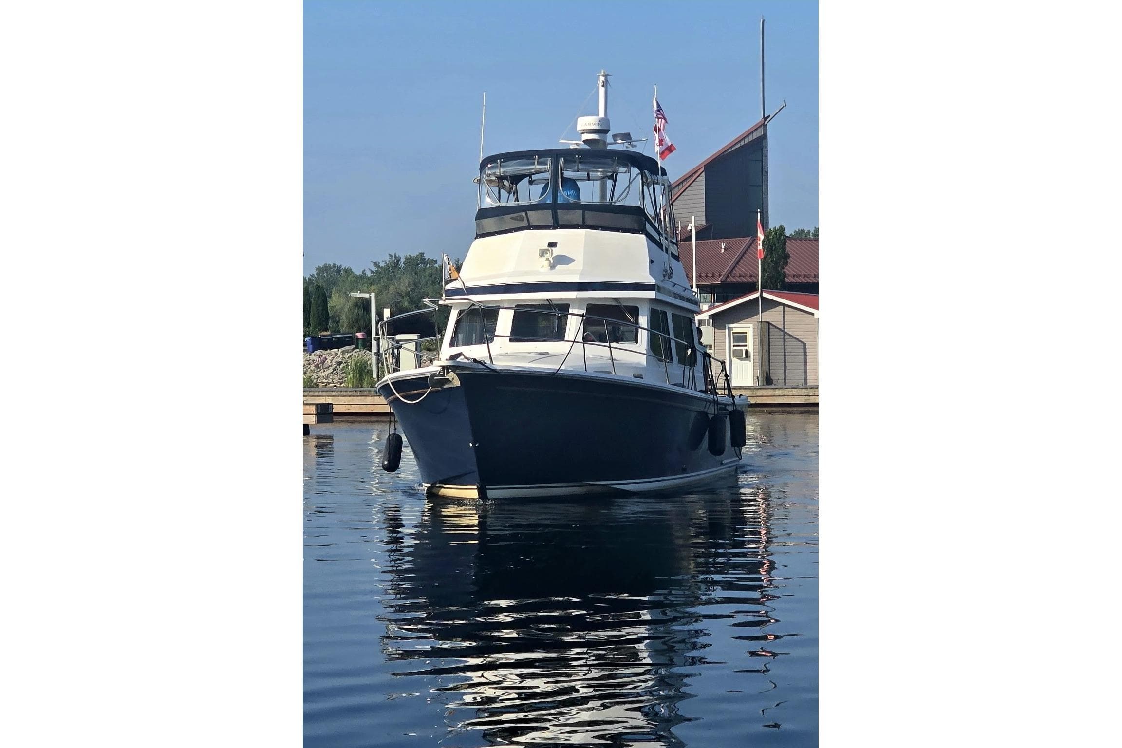 1999 Sabre 34 yacht docked in a marina, reflecting on calm water.