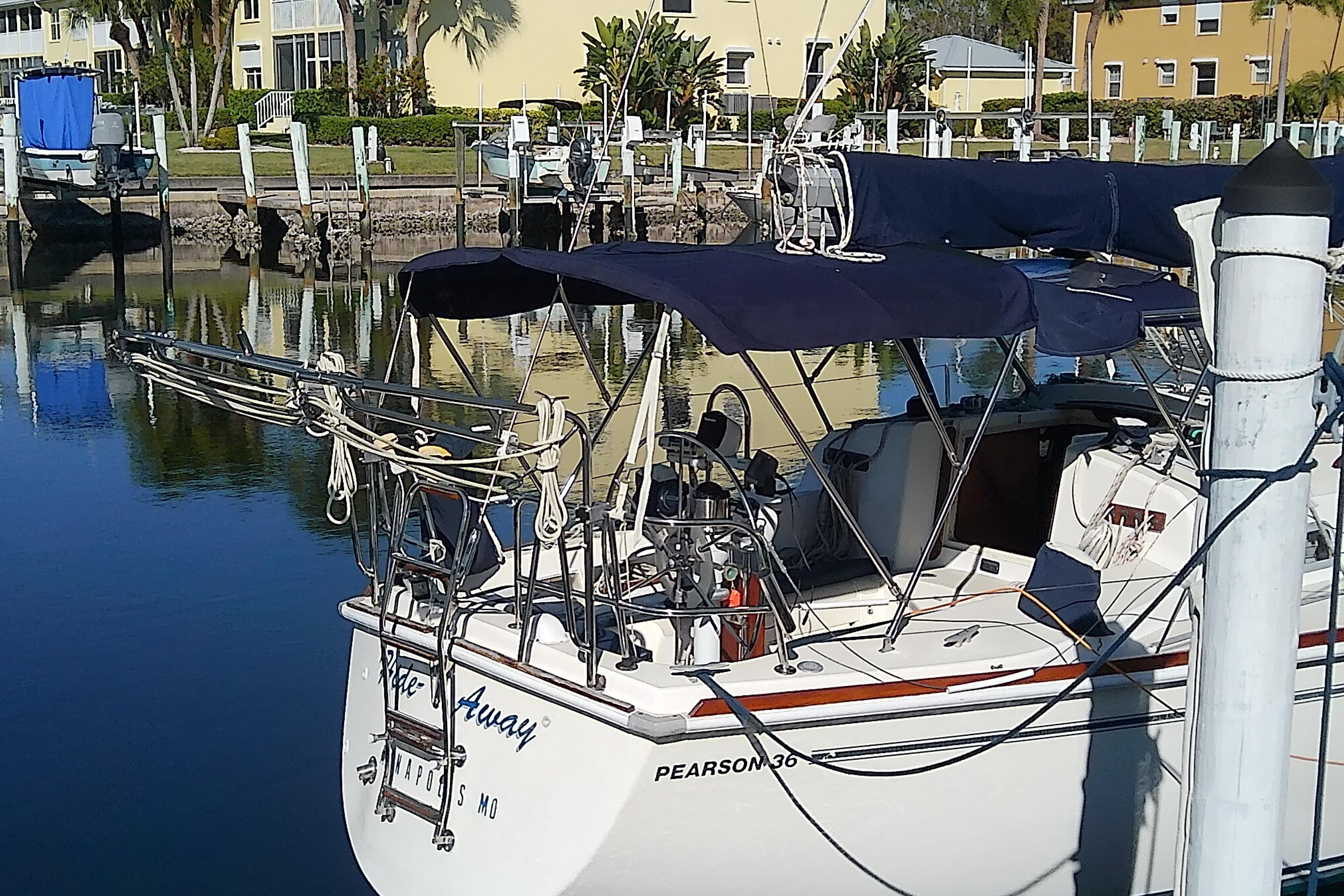 1988 Pearson 36-2 sailboat docked in a marina, featuring blue canvas covers.