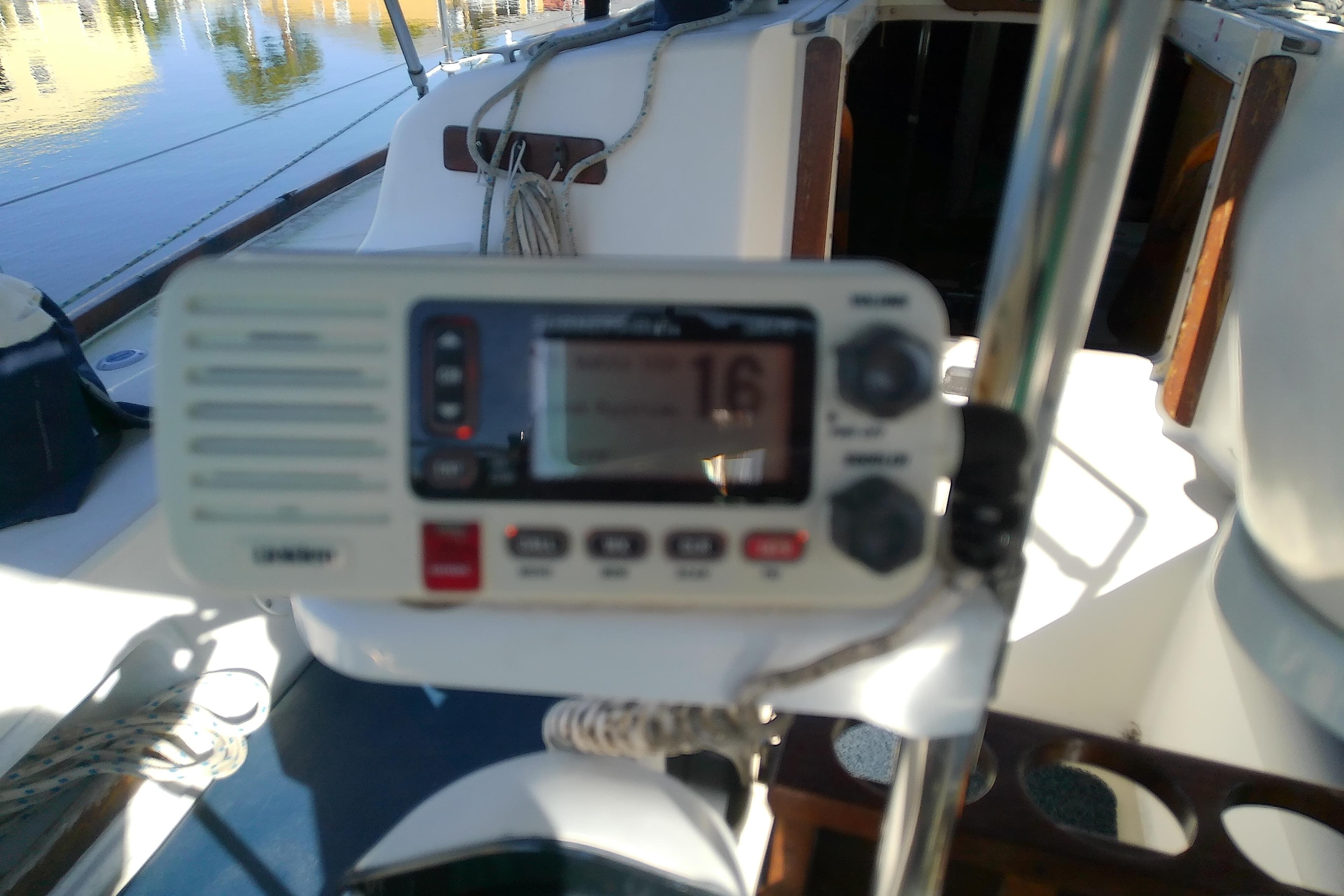 VHF radio on 1988 Pearson 36-2 sailboat cockpit, sunny day reflection.