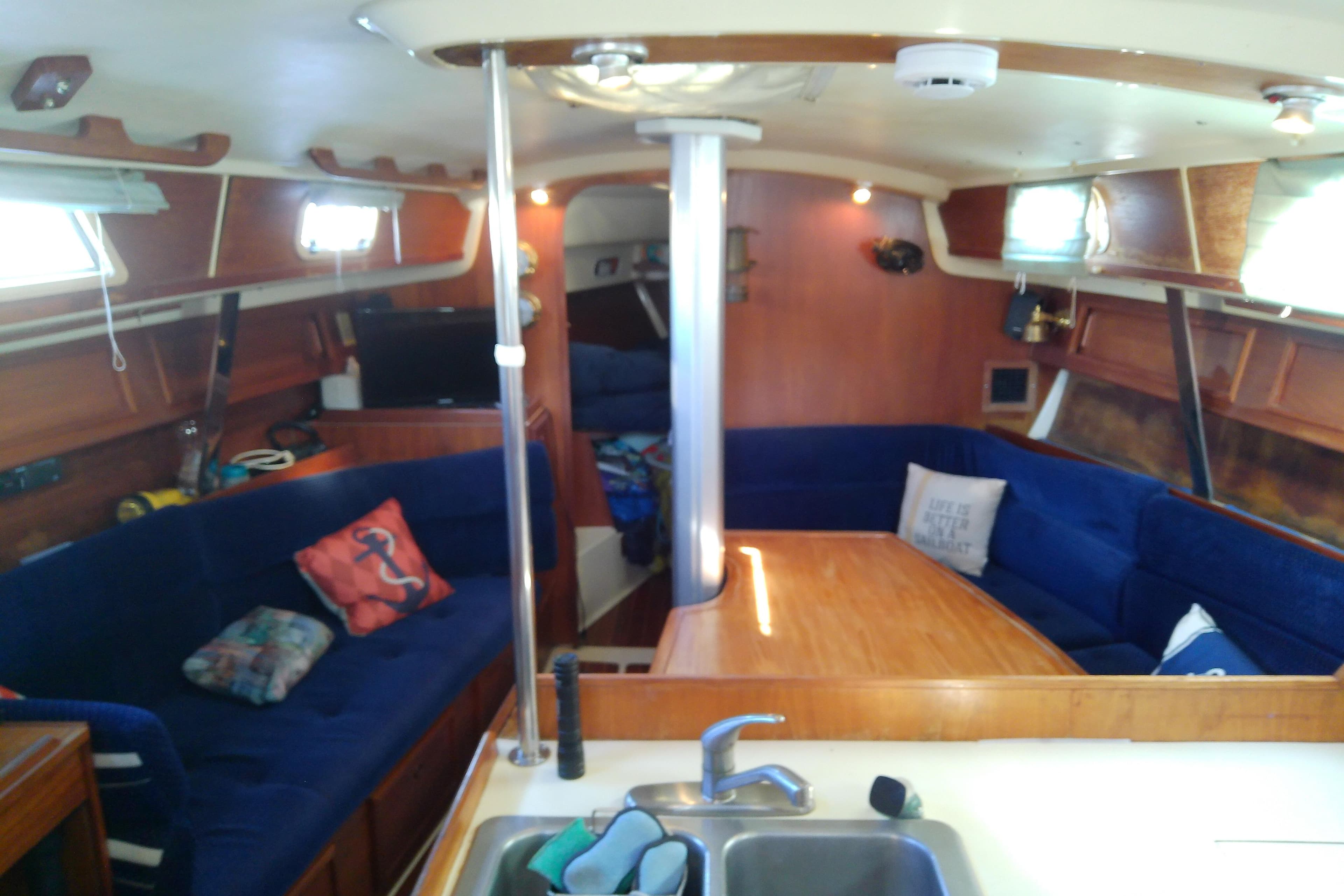 Interior of 1988 Pearson 36-2 sailboat with cozy seating and wooden table.