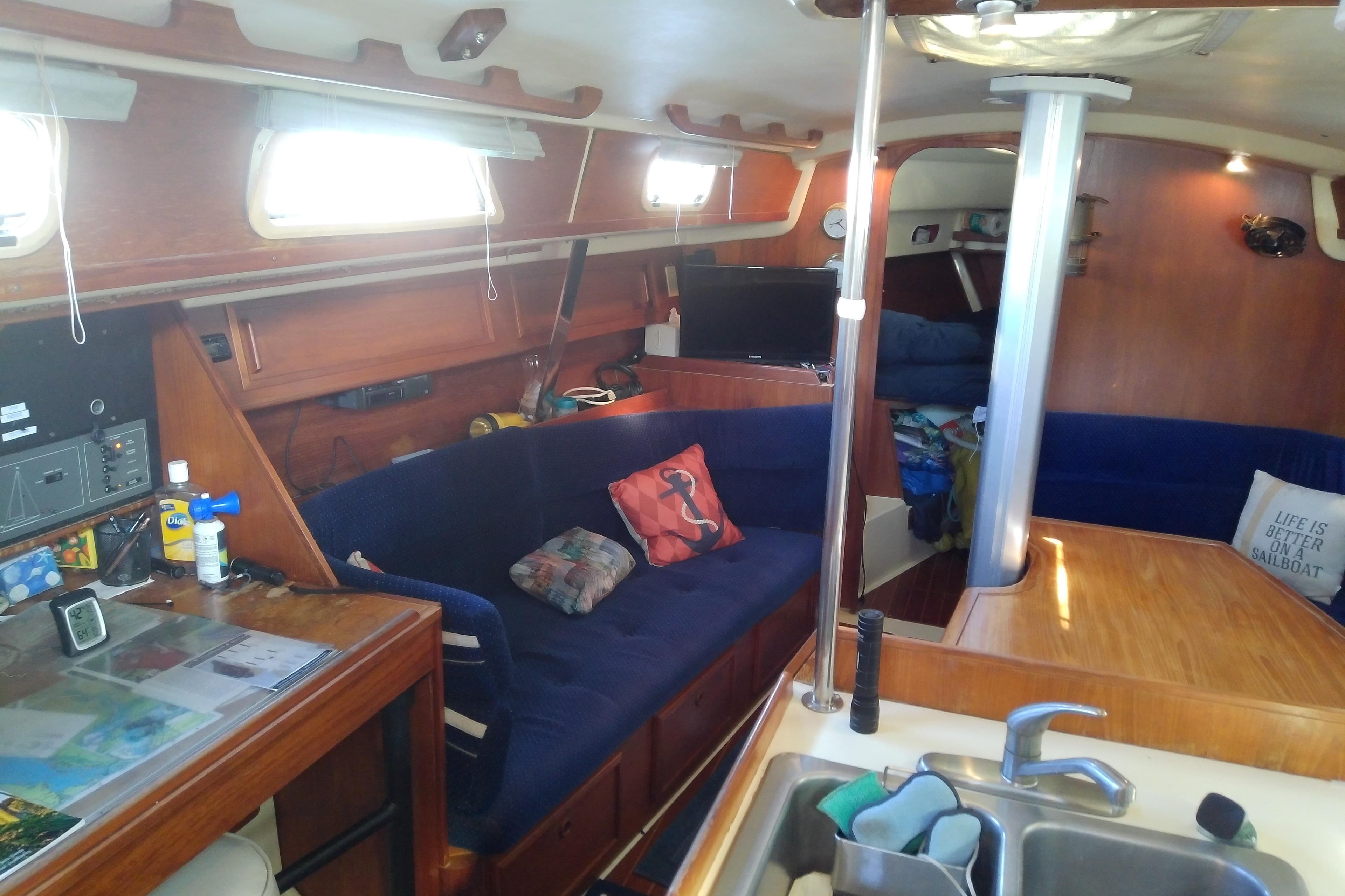 Interior of a 1988 Pearson 36-2 sailboat with cozy seating and wooden finishes.
