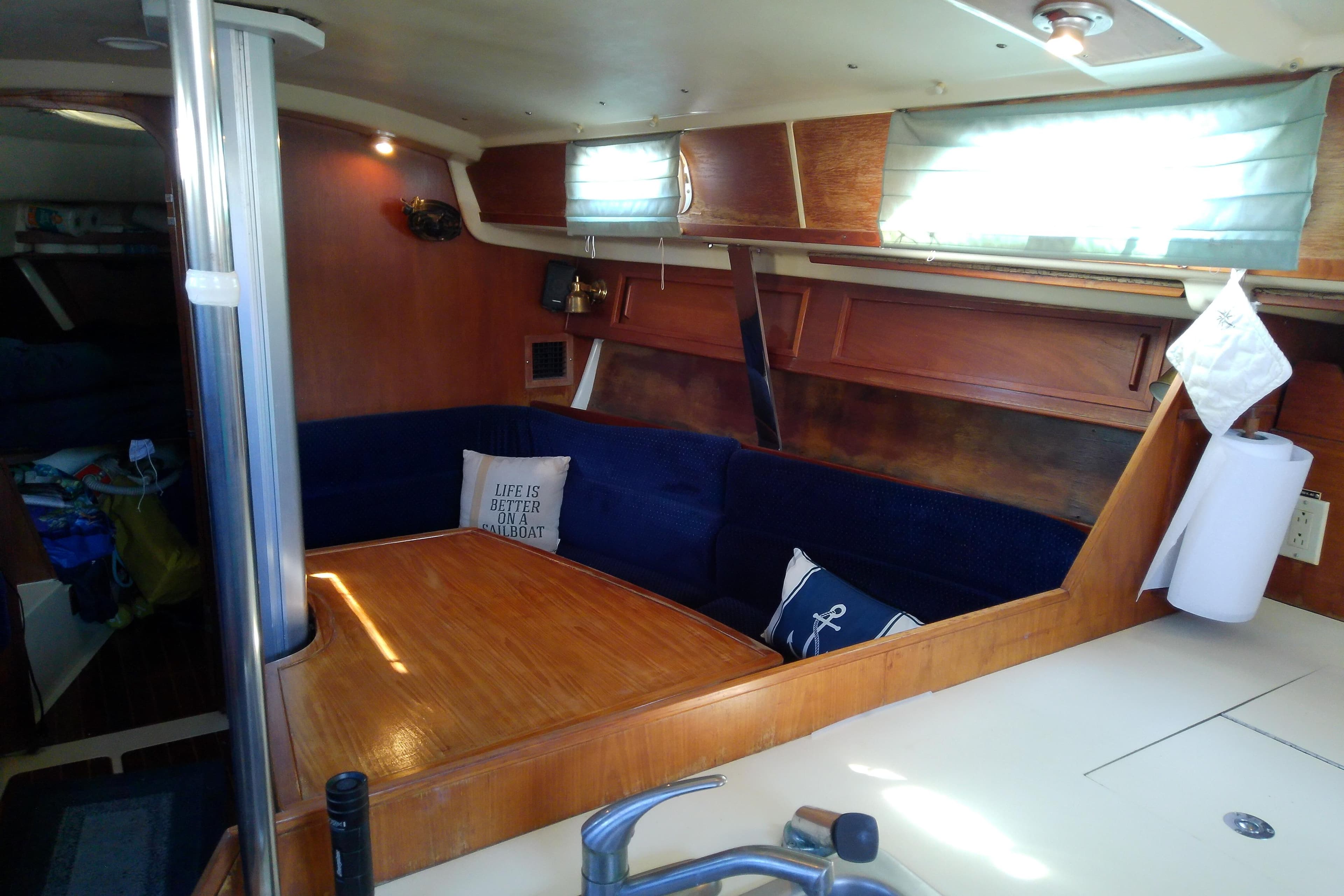 Interior of 1988 Pearson 36-2 sailboat with cozy seating and nautical decor.