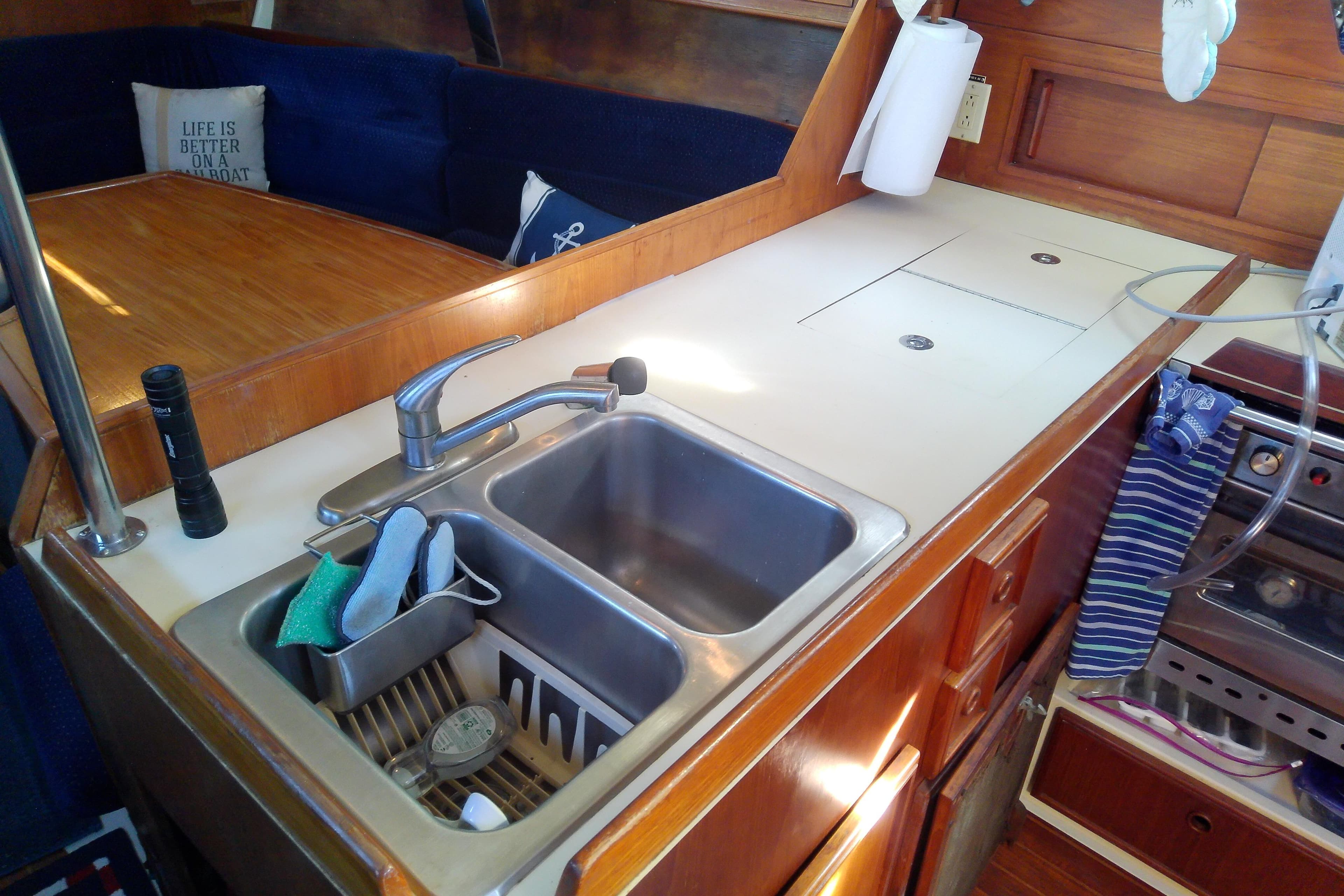 1988 Pearson 36-2 yacht interior with kitchen sink, wooden cabinetry, and cozy seating area.