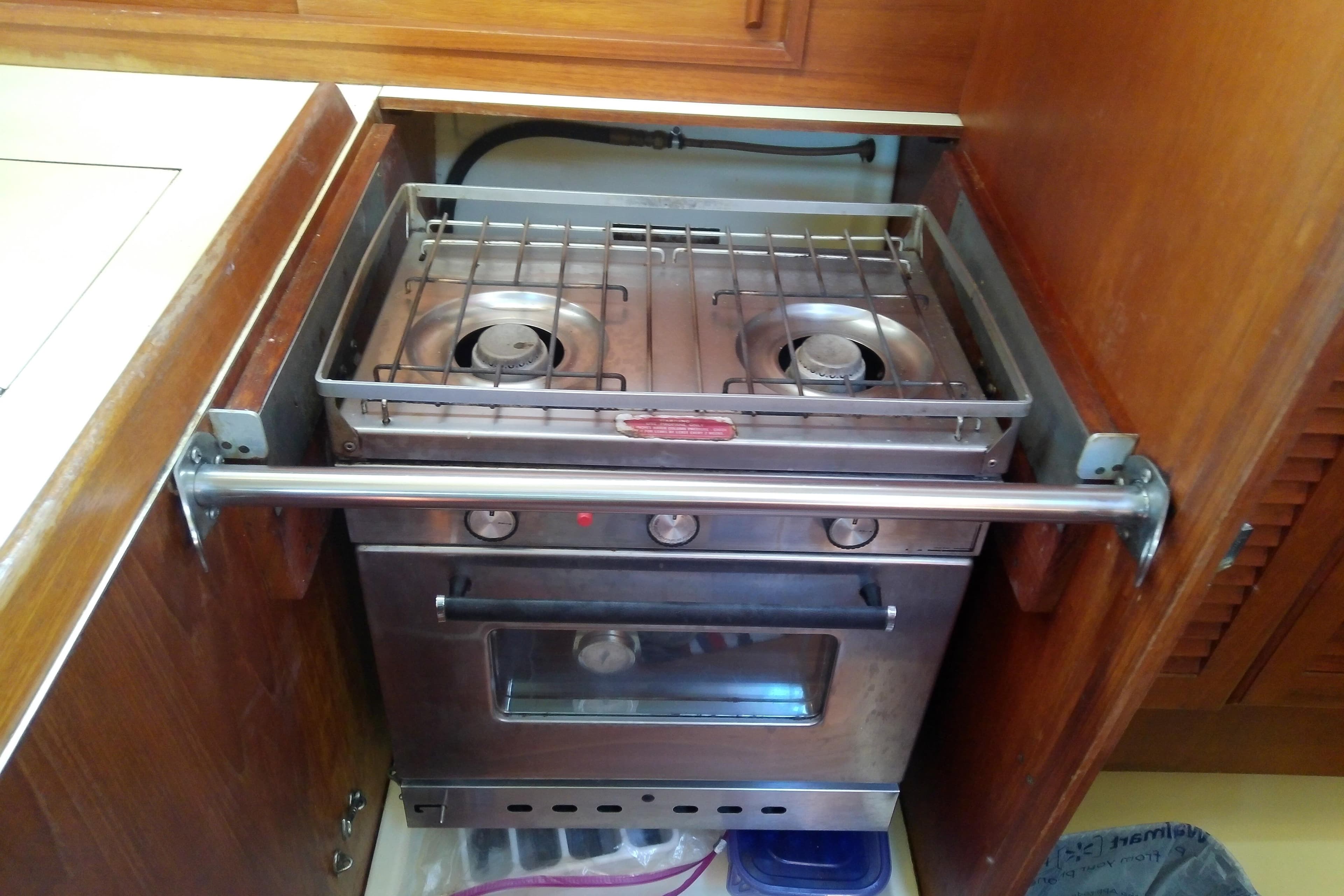Stainless steel stove in 1988 Pearson 36-2 yacht kitchen with wooden cabinetry.