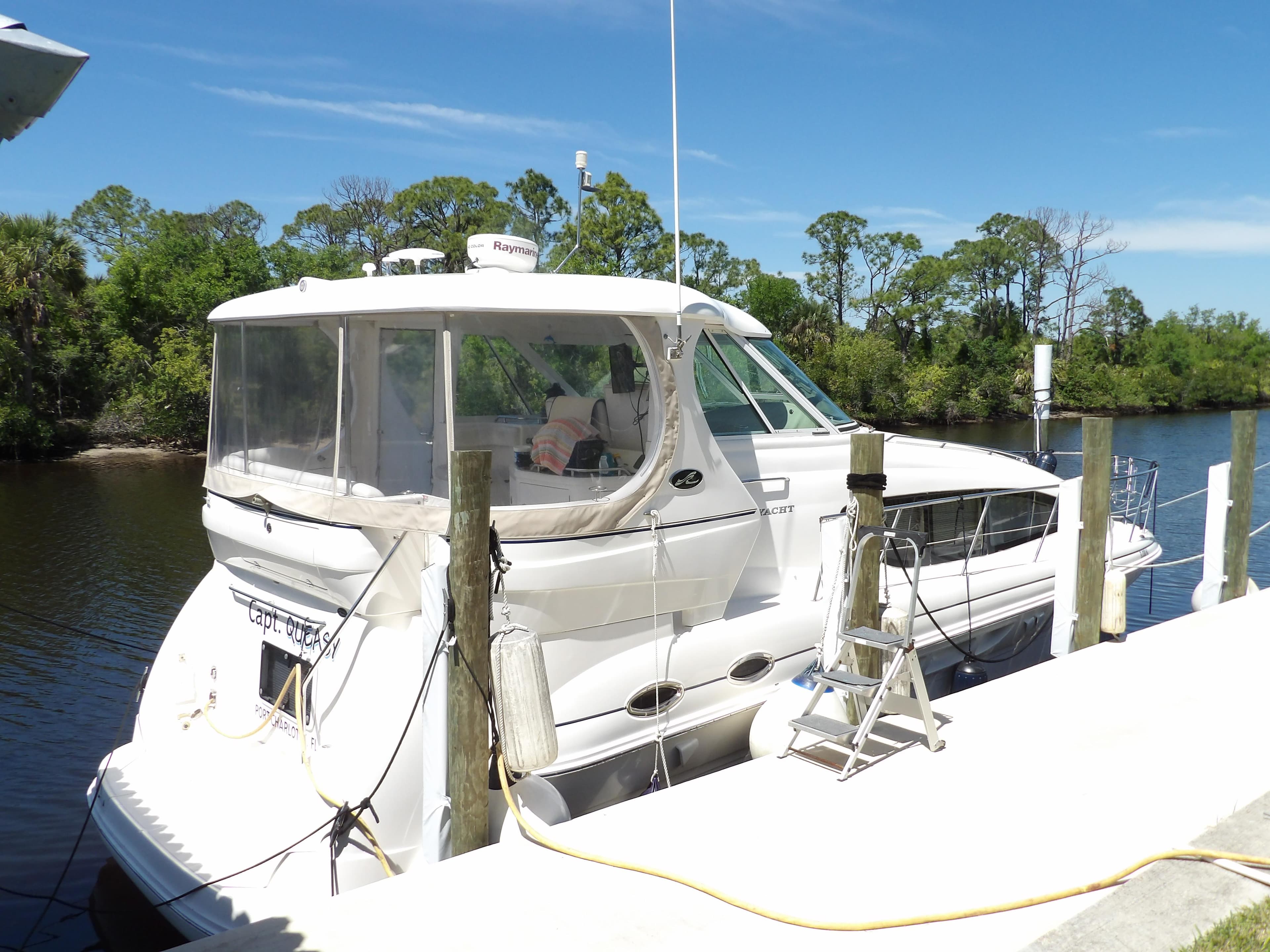 2003 Sea Ray 390 Motor Yacht docked by a serene river.