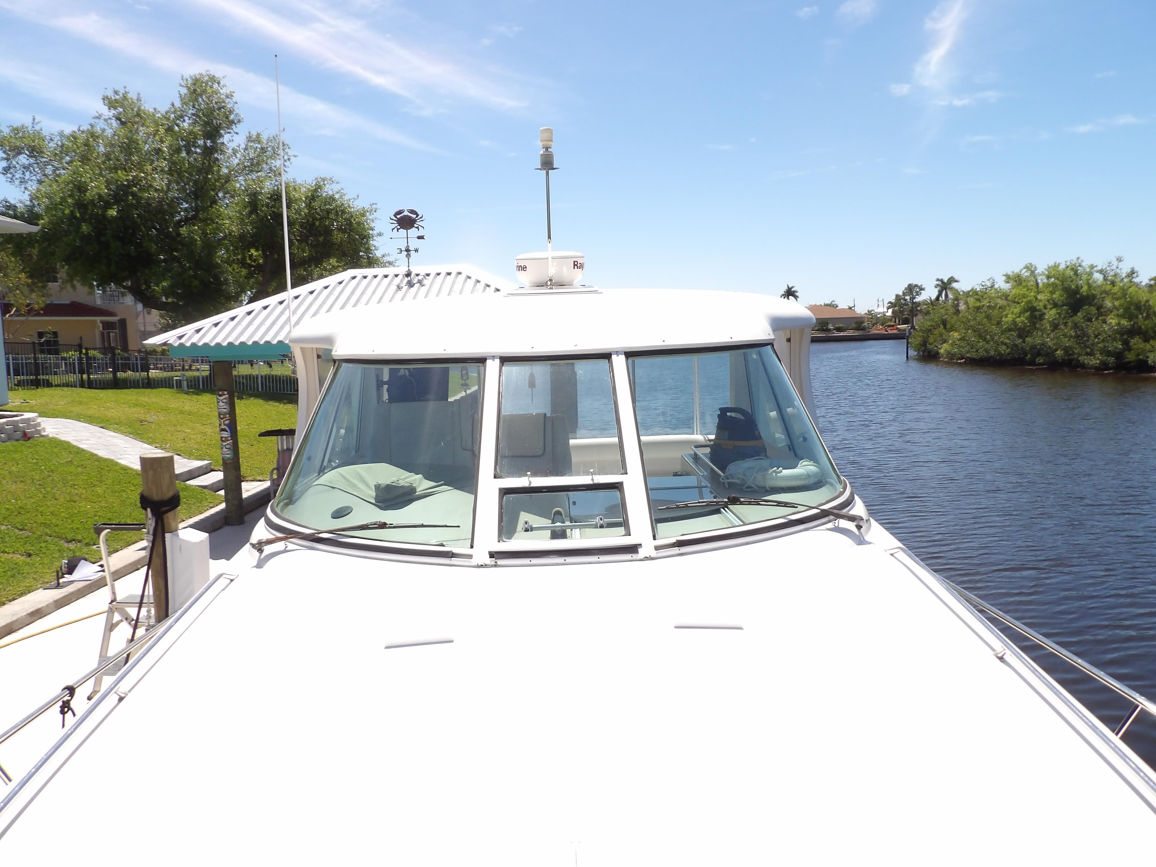 2003 Sea Ray 390 Motor Yacht docked by a serene waterfront.