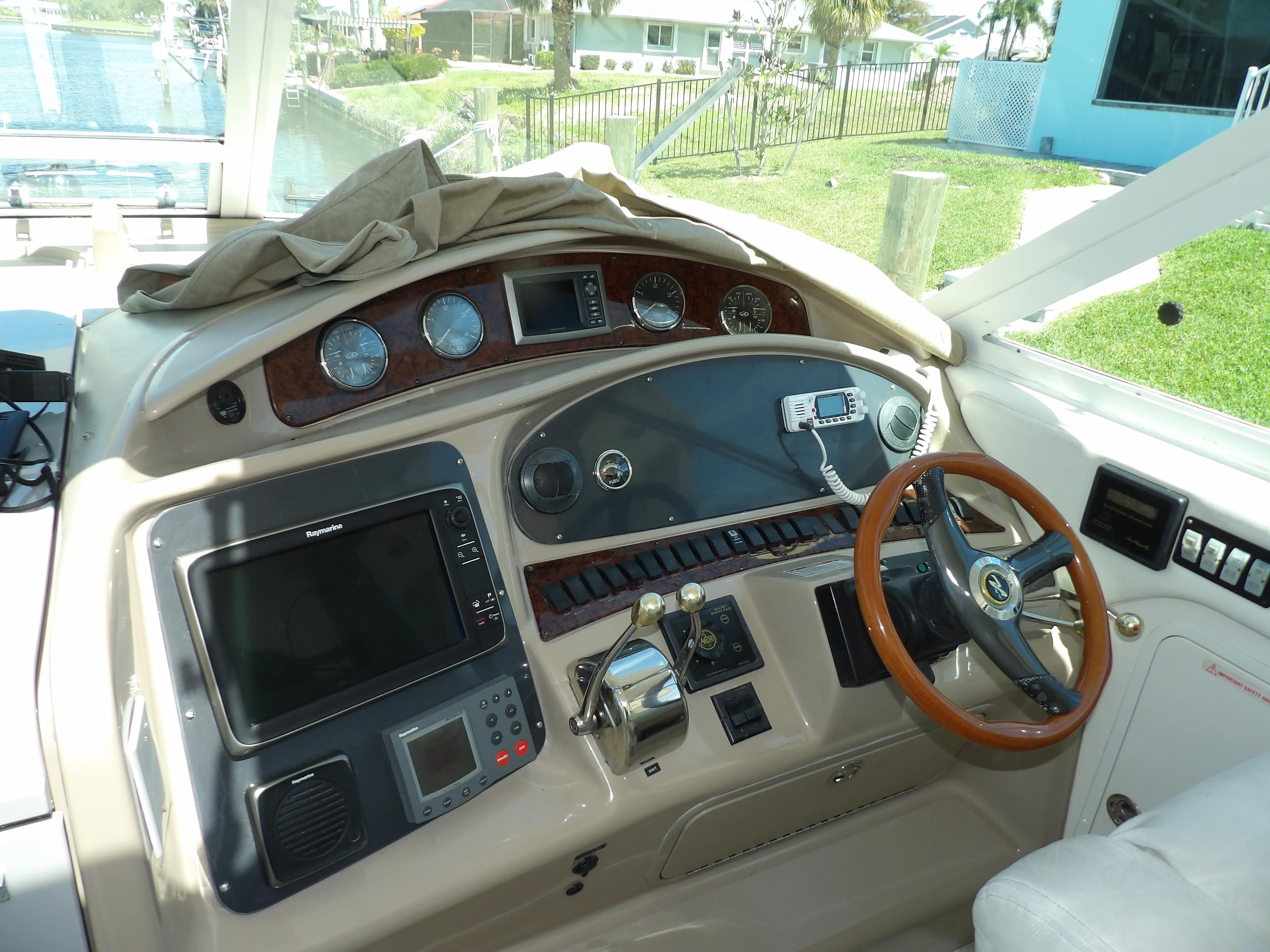 2003 Sea Ray 390 Motor Yacht helm with navigation instruments and wooden steering wheel.