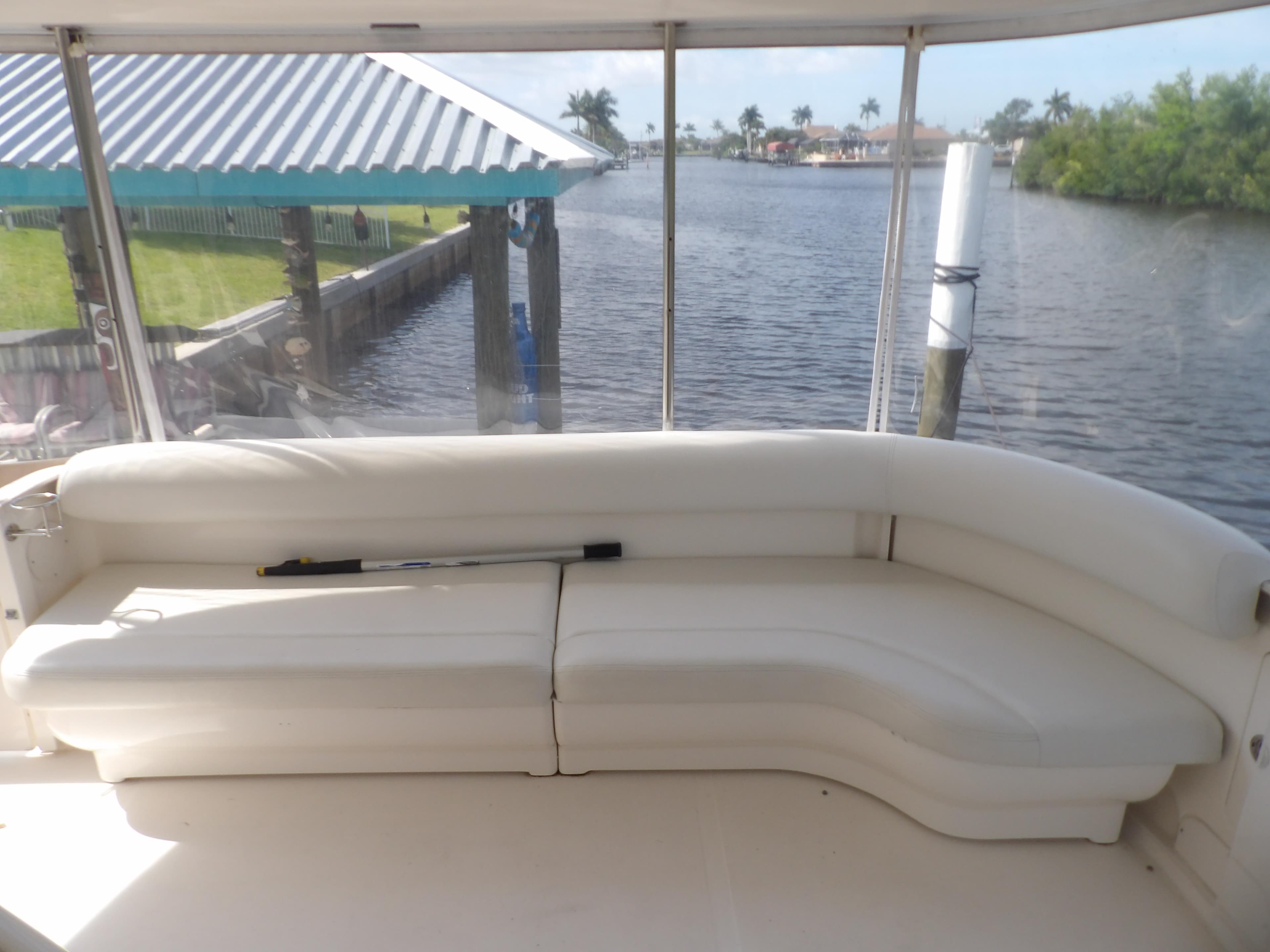 2003 Sea Ray 390 Motor Yacht interior with white seating and waterfront view.