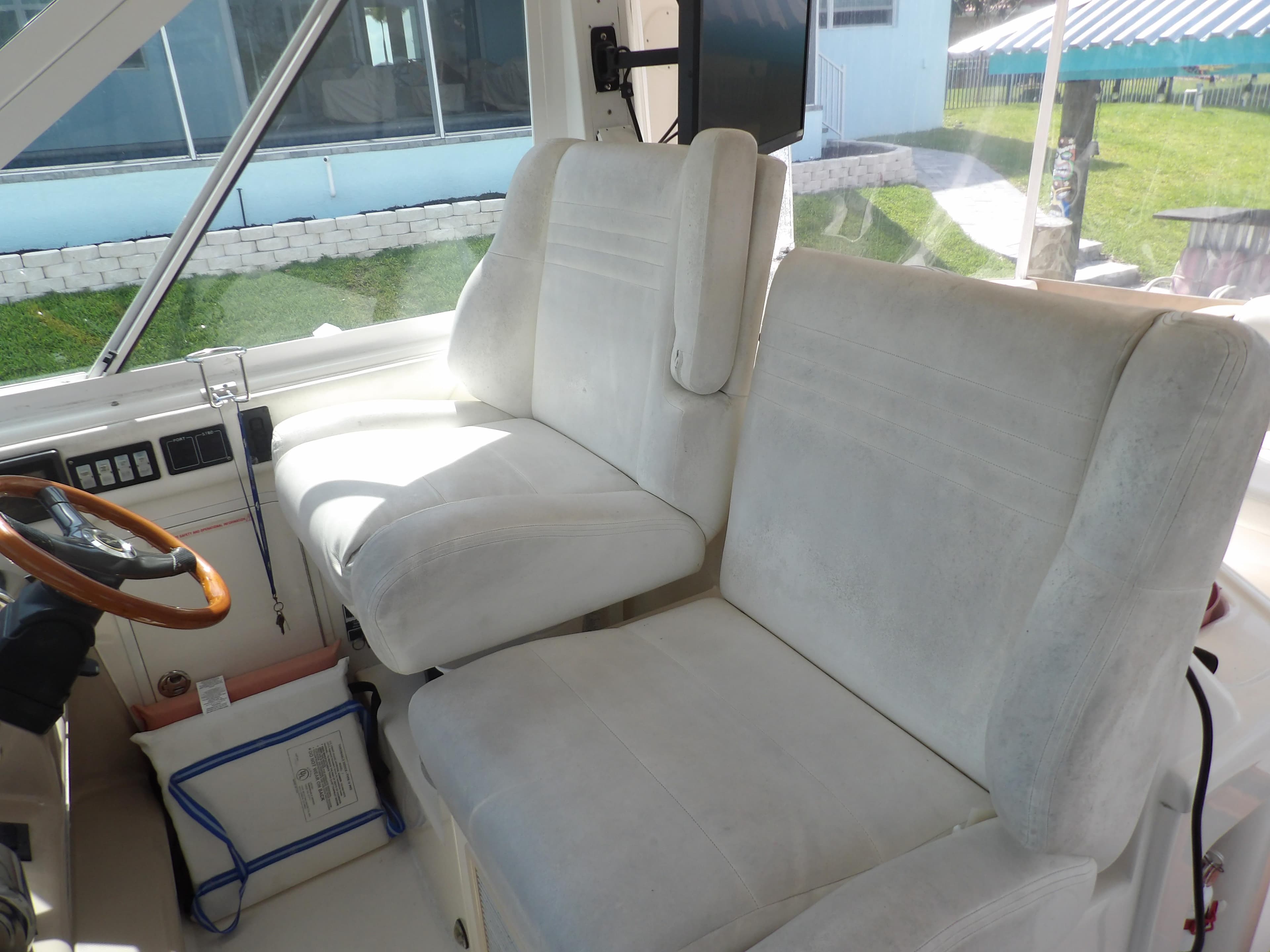 2003 Sea Ray 390 Motor Yacht helm seats with white upholstery.