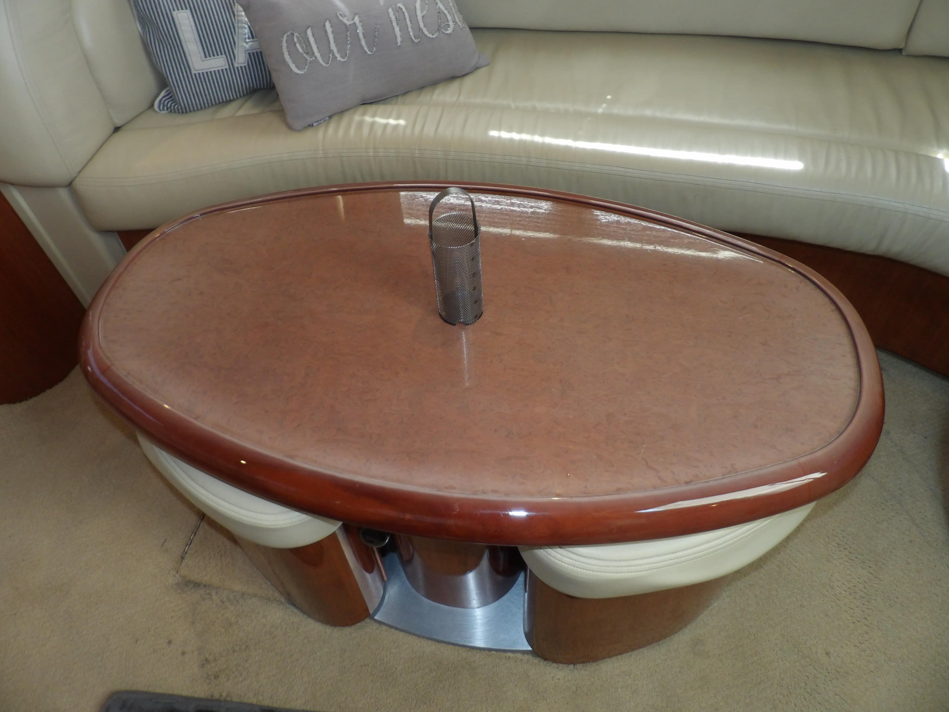 Interior of 2003 Sea Ray 390 Motor Yacht with oval wooden table and beige seating.