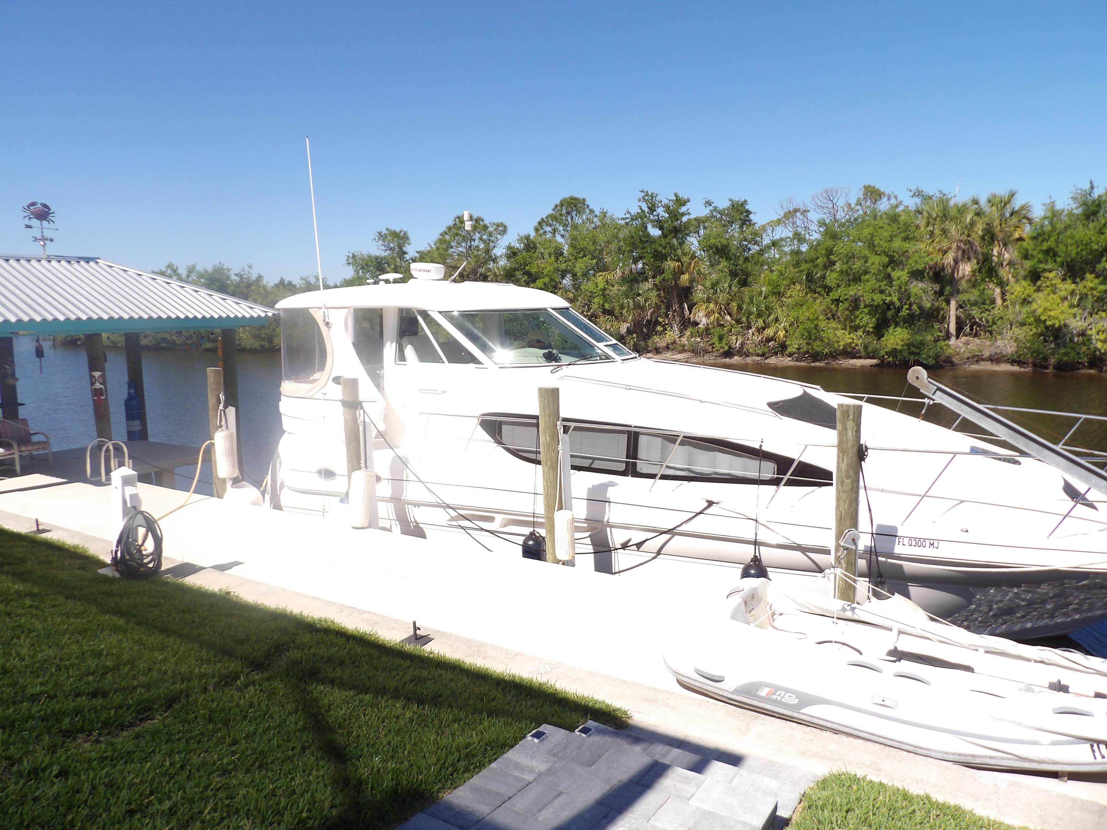 2003 Sea Ray 390 Motor Yacht docked by a riverside.