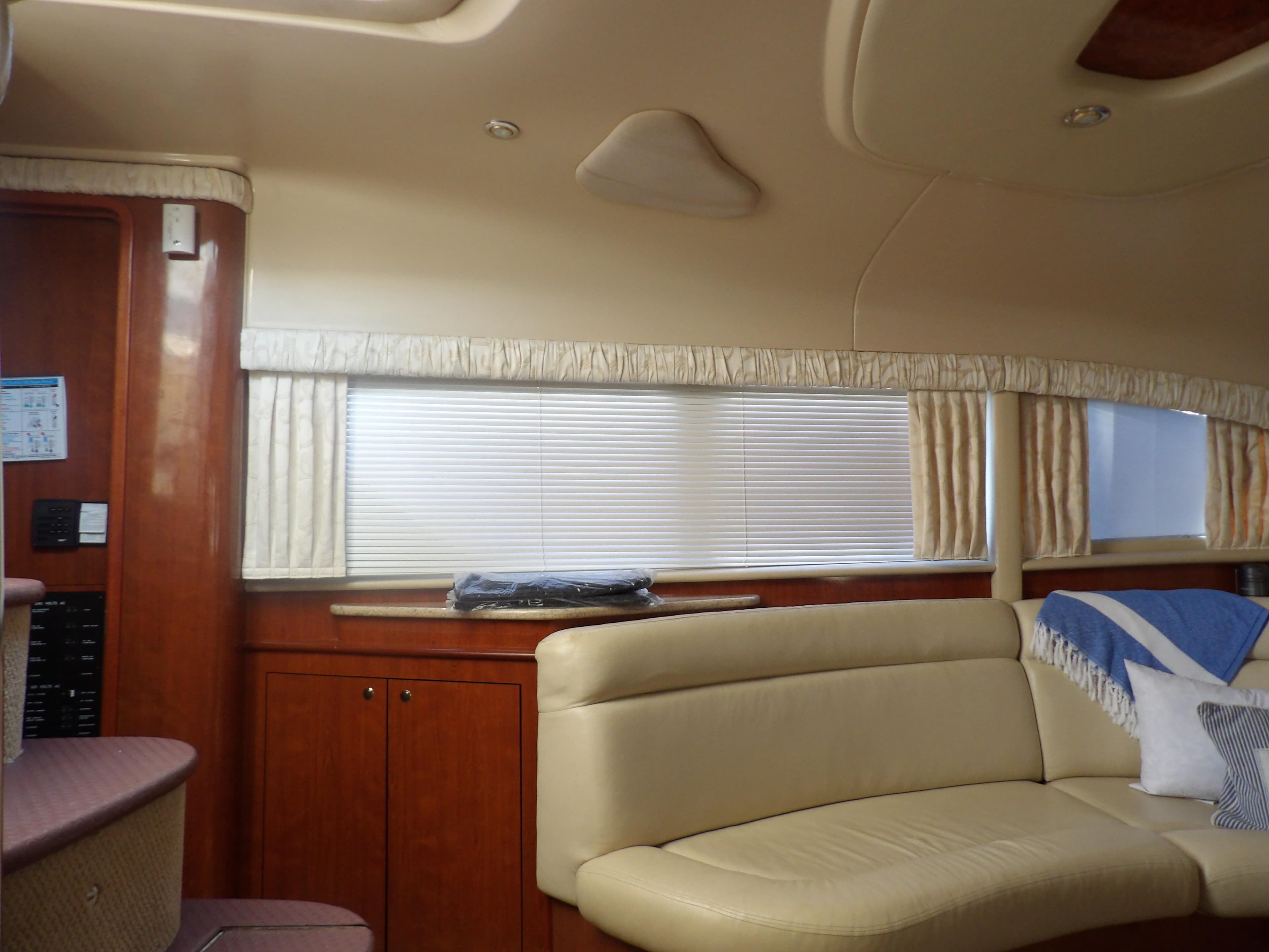 Interior of 2003 Sea Ray 390 Motor Yacht with beige leather seating and wooden cabinetry.
