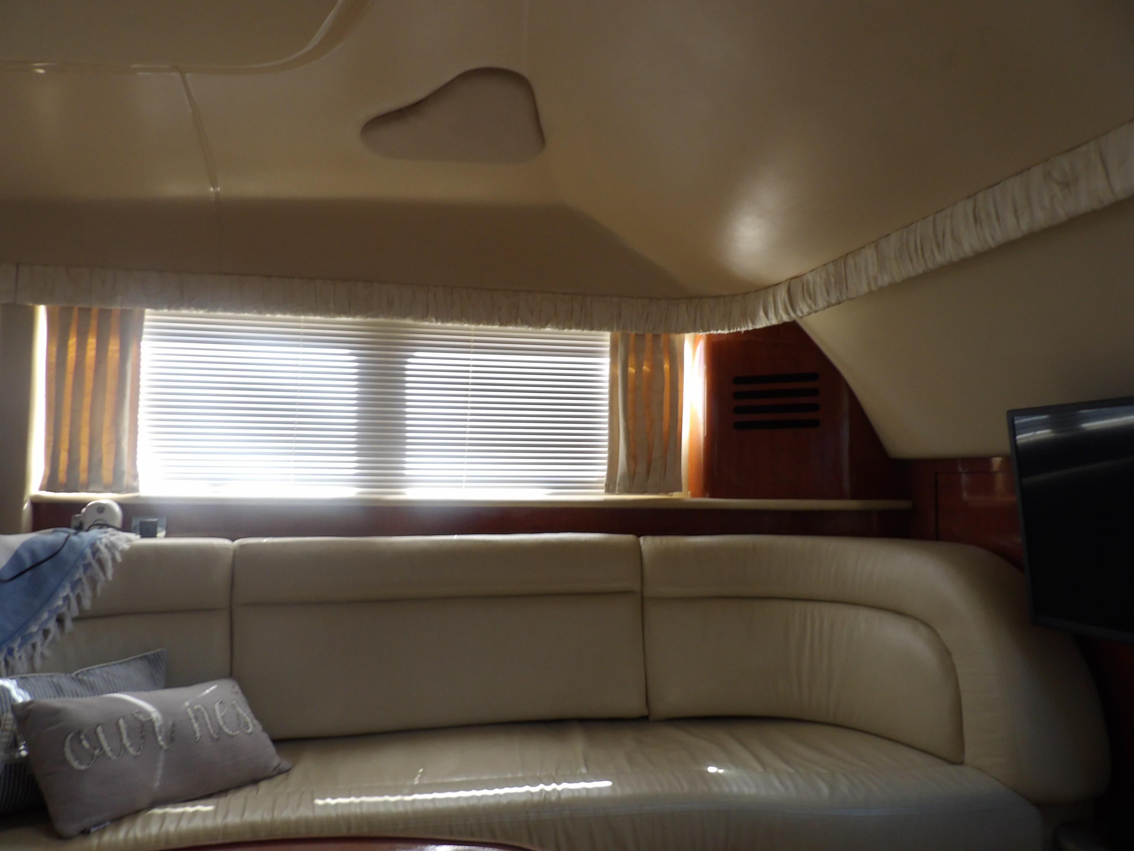 Interior of 2003 Sea Ray 390 Motor Yacht with beige leather seating and window blinds.