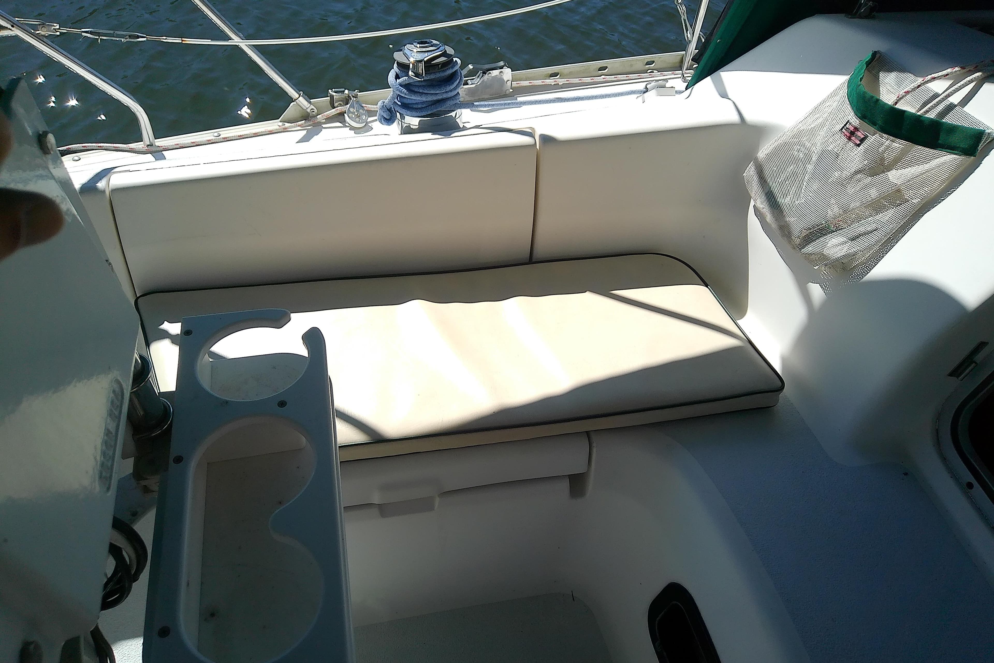 Interior of a 1991 Hunter 30 sailboat with cushioned seating and cup holders.