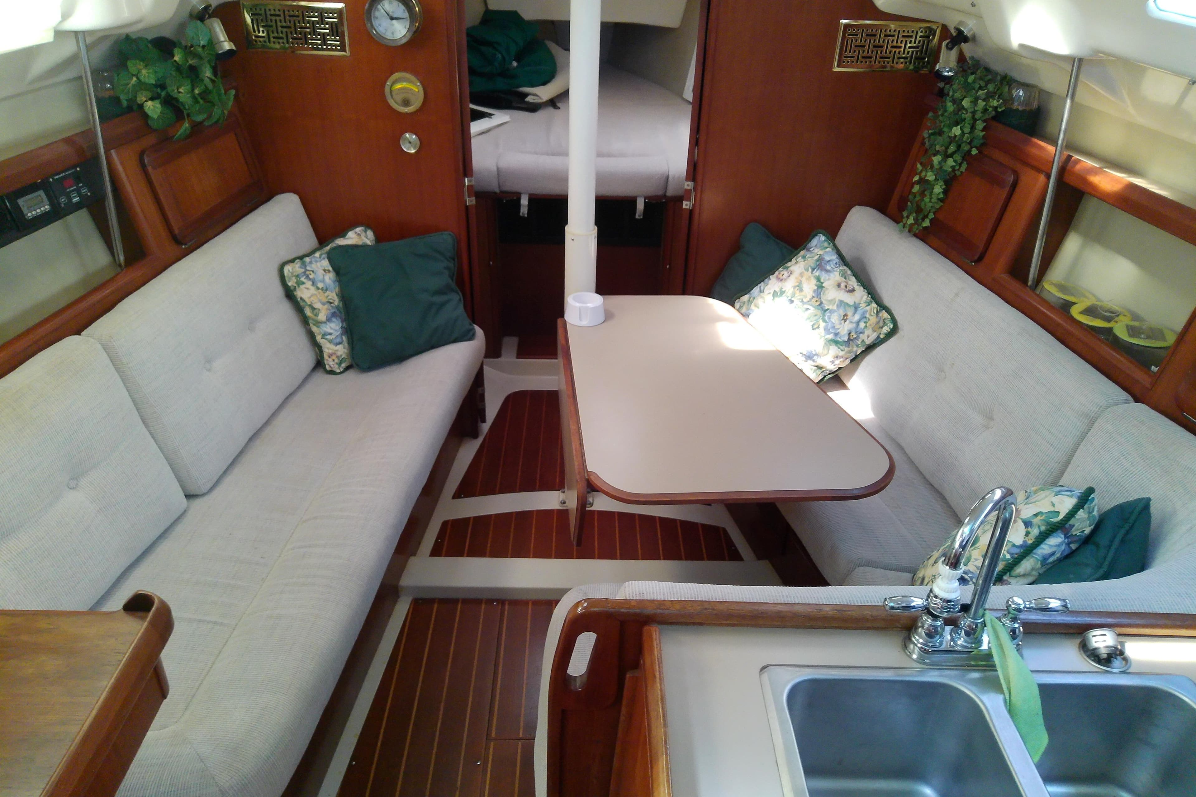 Interior of a 1991 Hunter 30 sailboat with cozy seating and a dining table.