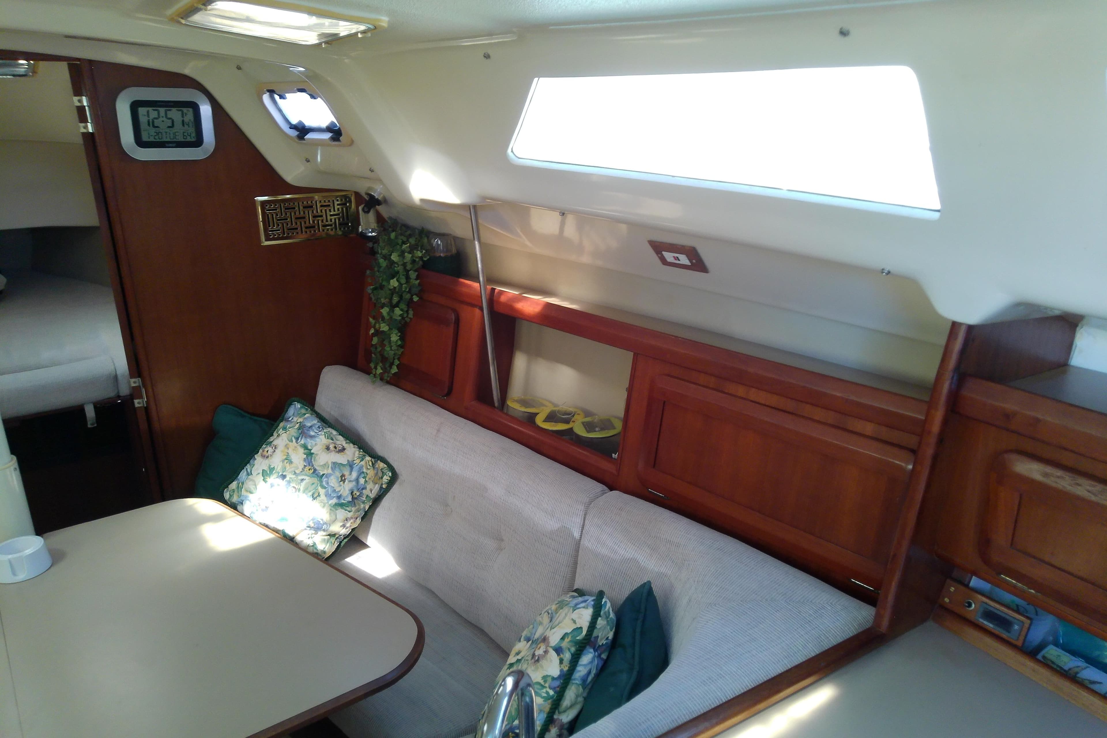 Cozy interior of a 1991 Hunter 30 sailboat with seating and wooden cabinetry.